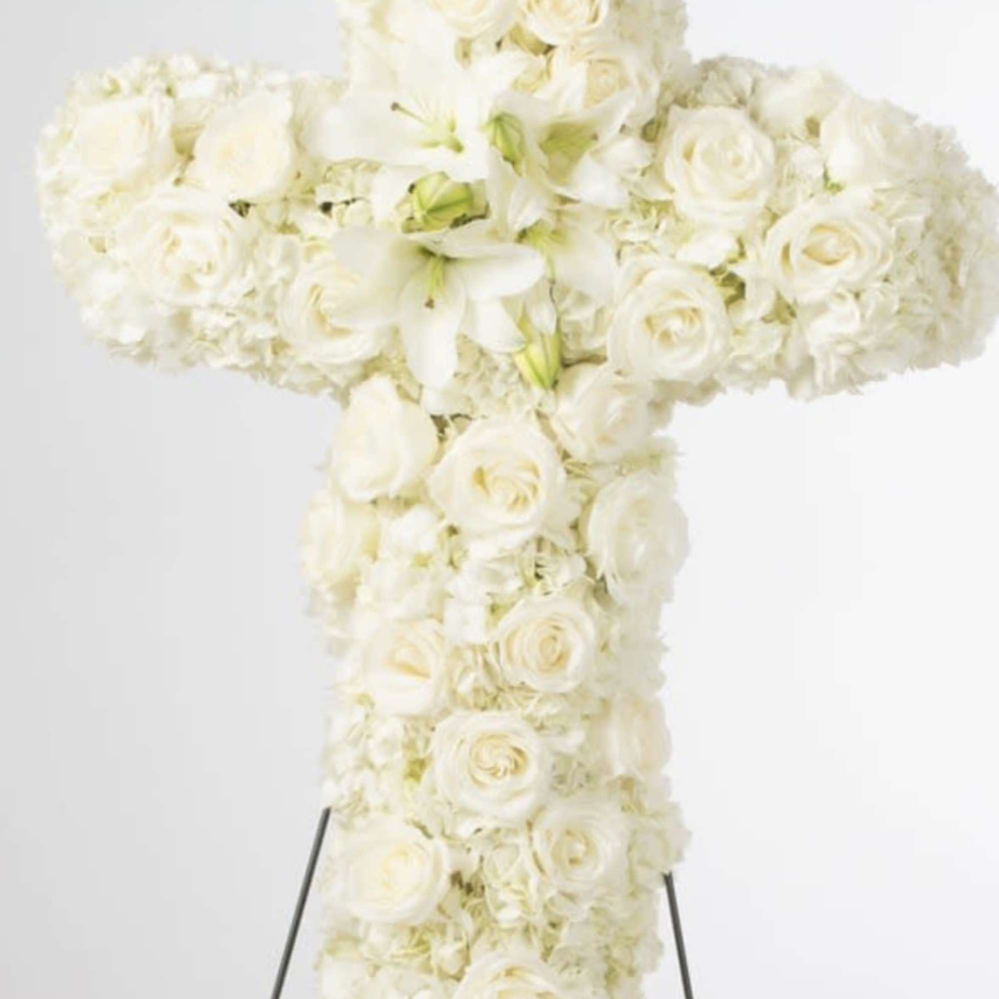 An all white tribute, this white cross funeral spray is pure and