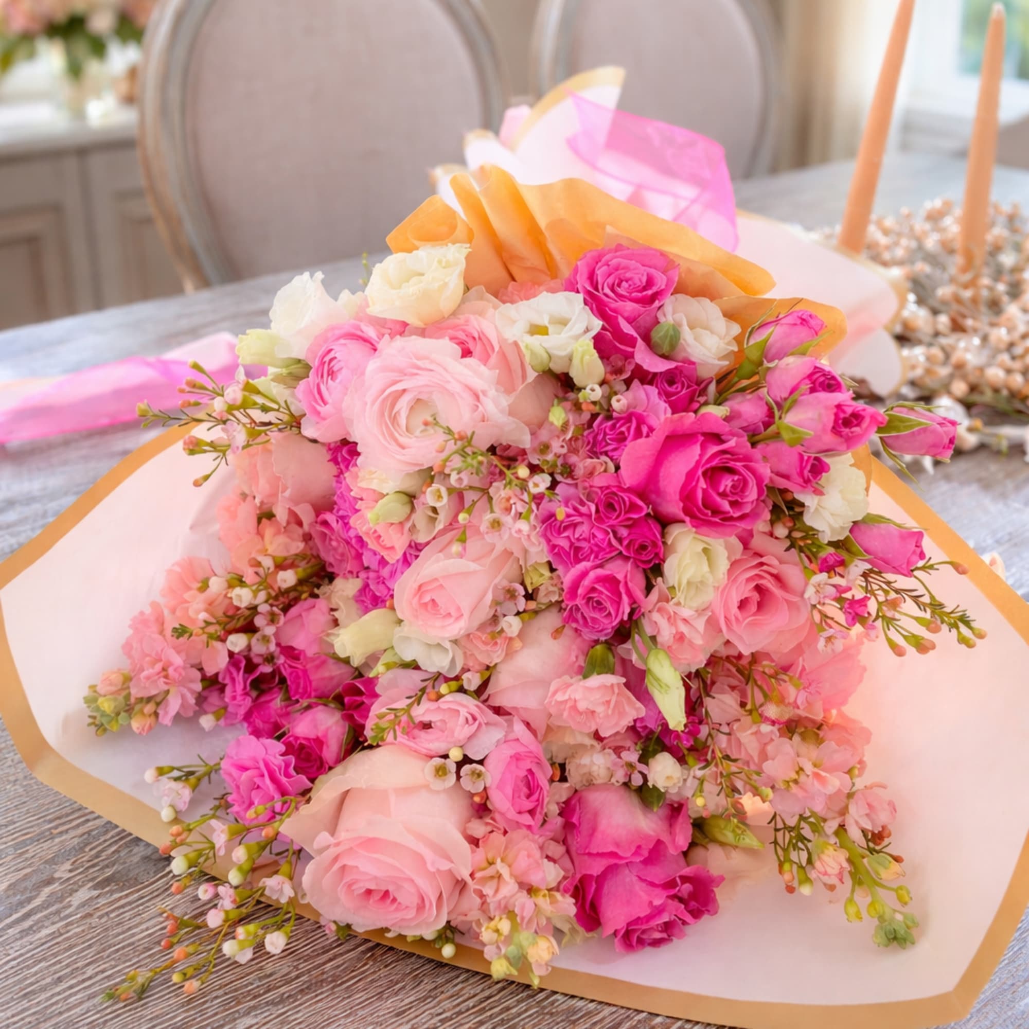 A hand-tied bouquet of lush pink and blush blooms, thoughtfully wrapped in