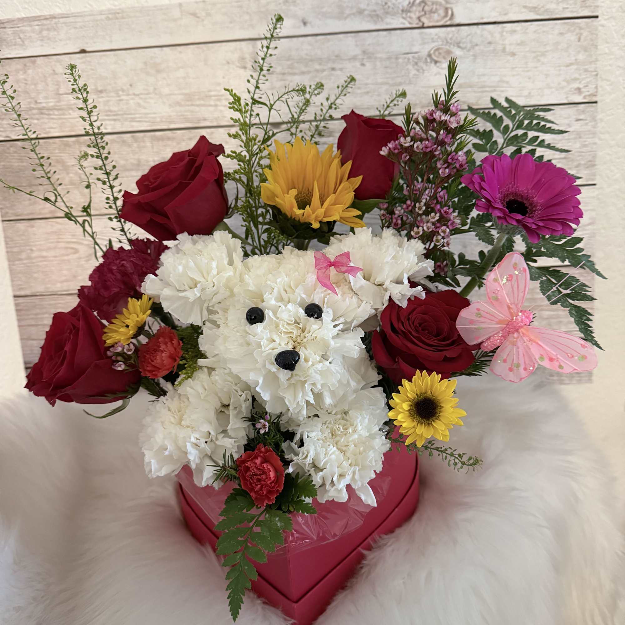 This charming arrangement features an adorable puppy handcrafted from fresh white carnations