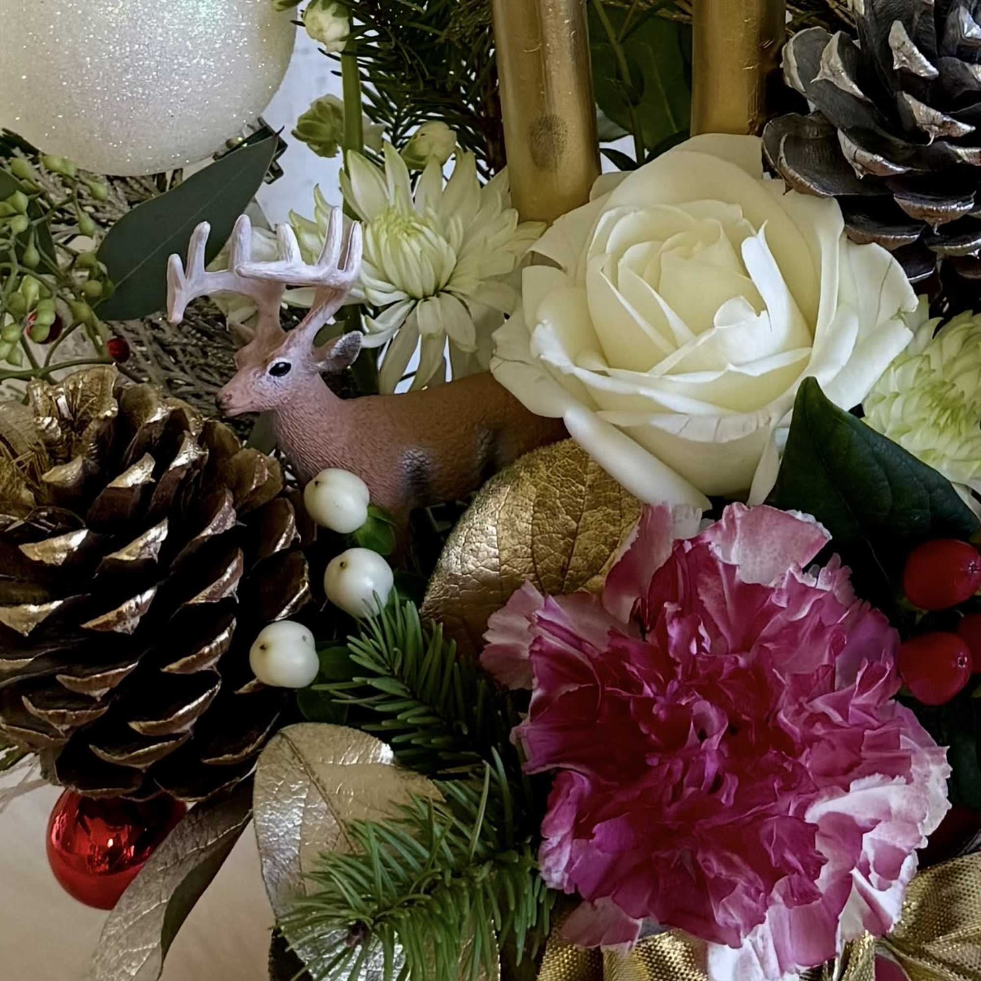 A festive holiday arrangement featuring elegant white roses, a vibrant pink carnation