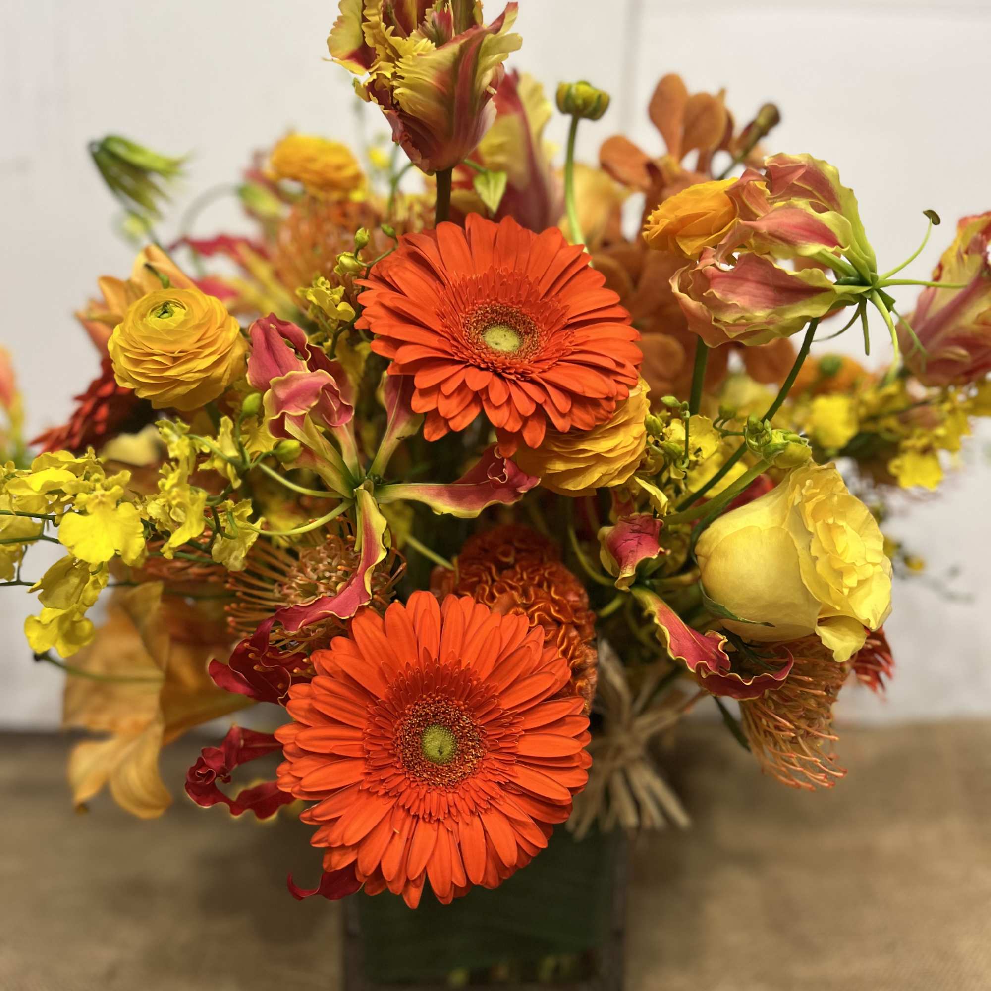 Medium high floral arrangement compose of an assortment of, yellow roses, nutan