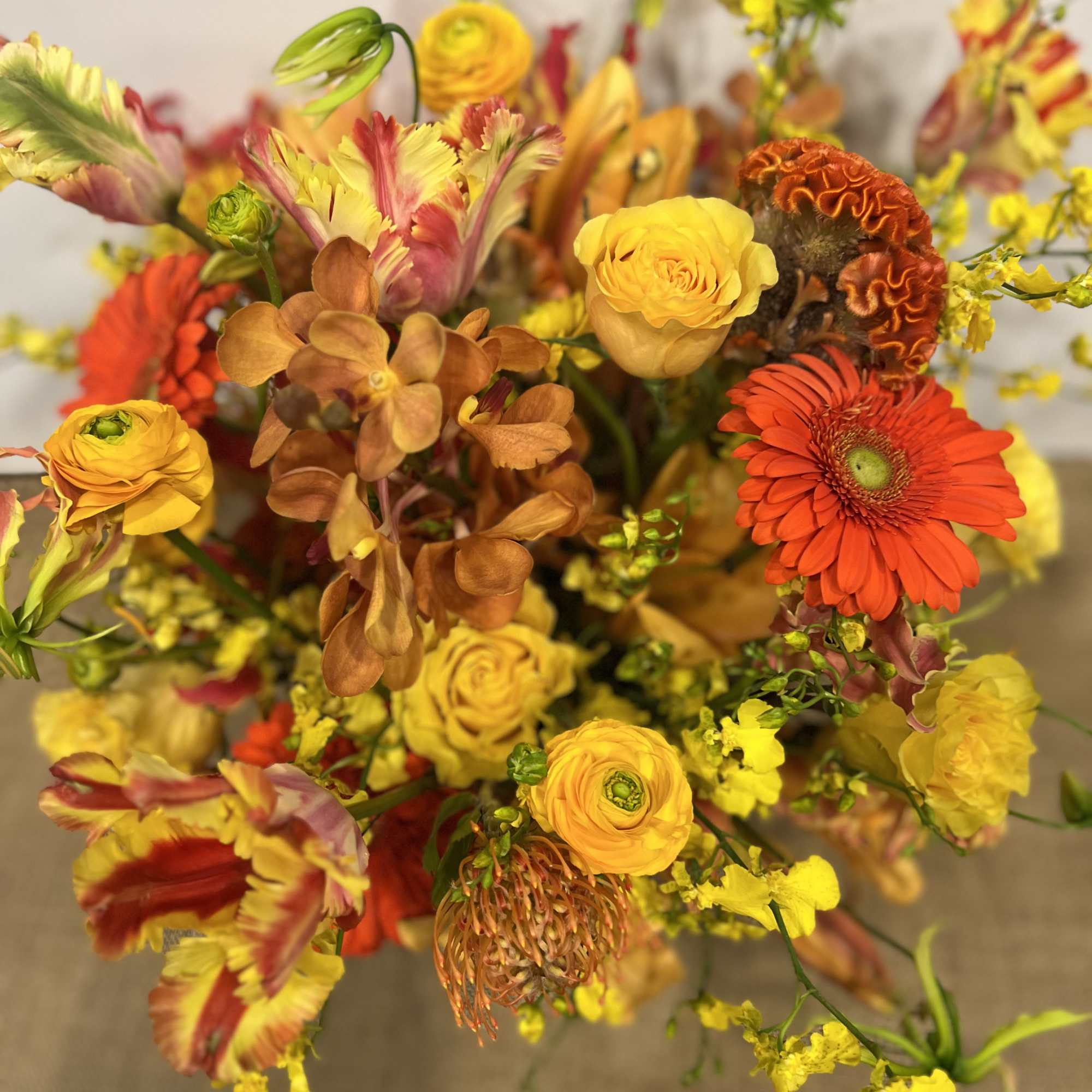 Medium high floral arrangement compose of an assortment of, yellow roses, nutan