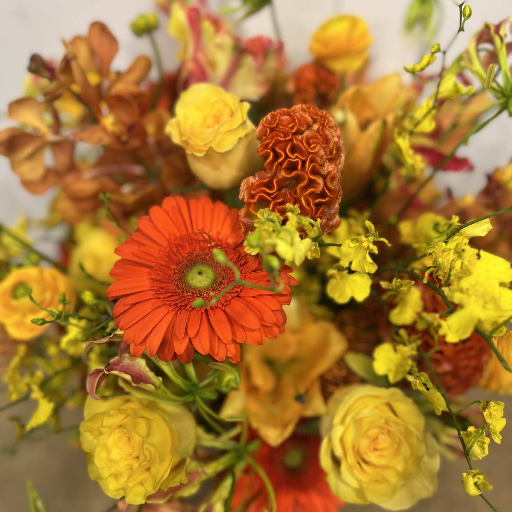 Medium high floral arrangement compose of an assortment of, yellow roses, nutan