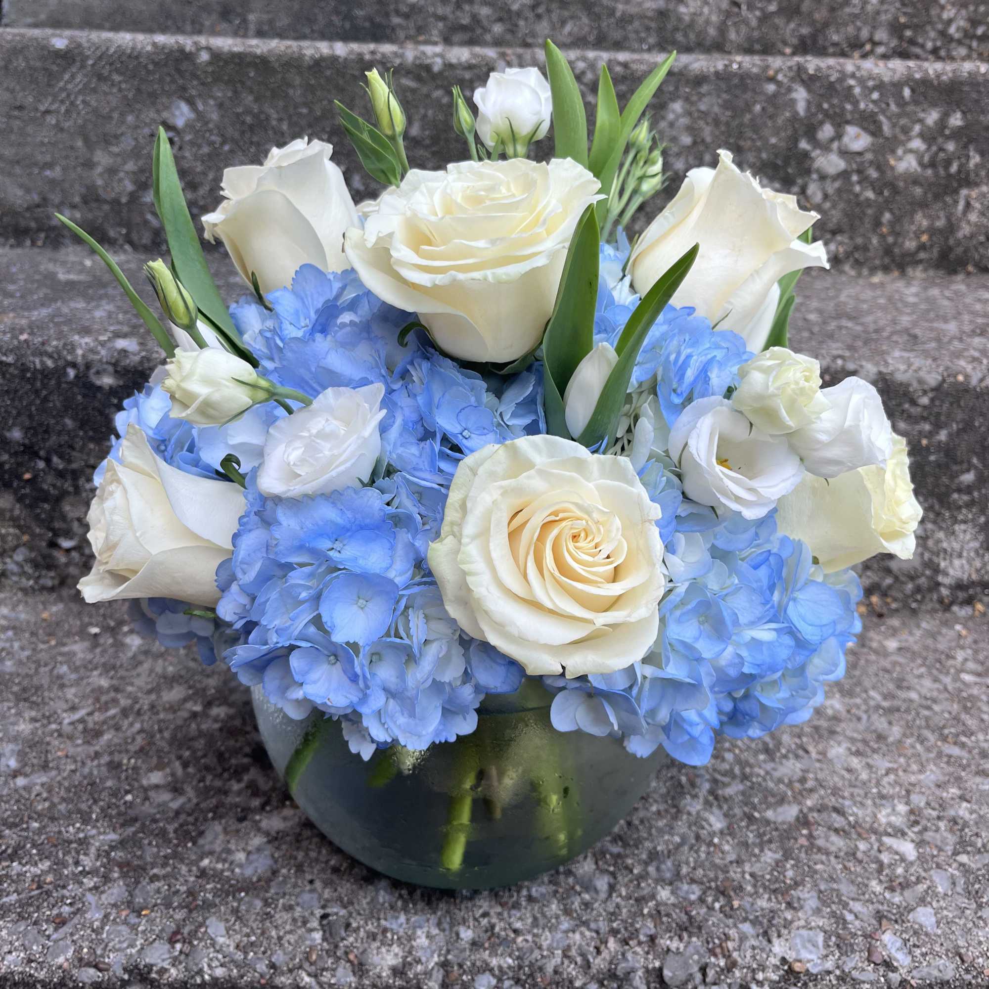 This arrangement has roses, hydrangeas, tulips, and lisianthus. The picture shown above