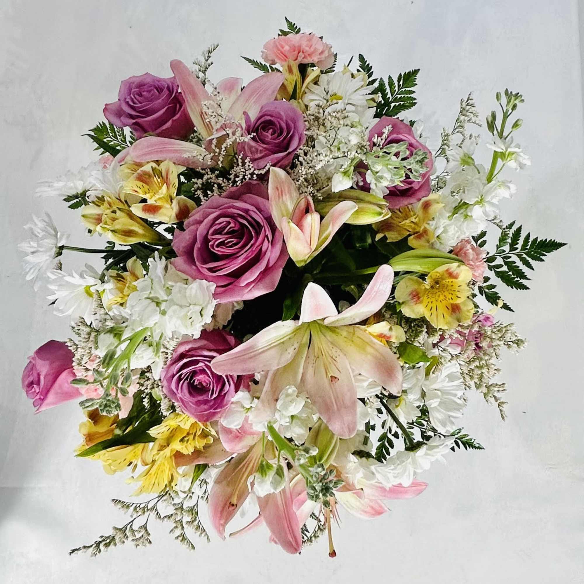  An eye-catching display of lavender roses and pink lilies is perfectly