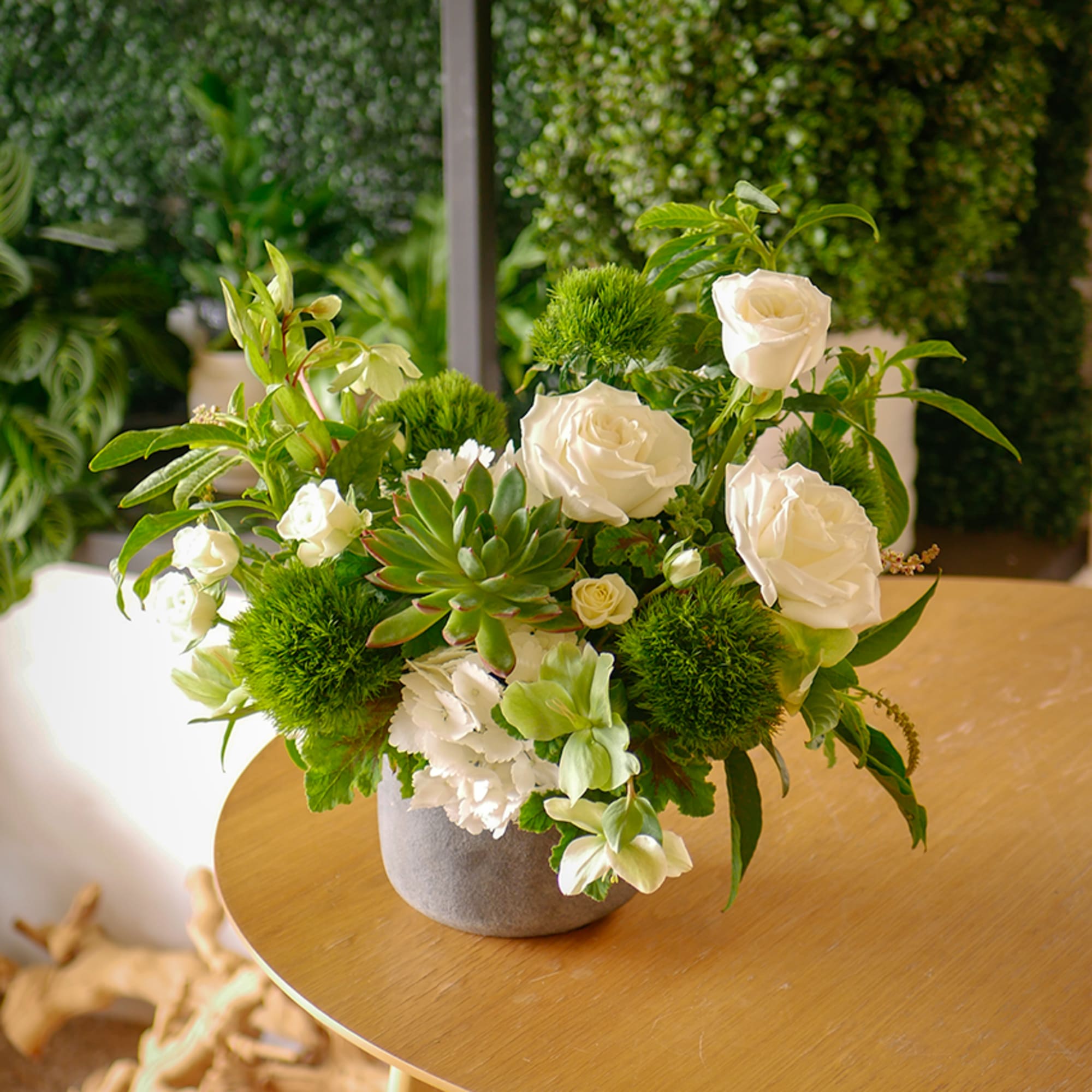 This flower arrangement features an artistic combination of delicate white blossoms such
