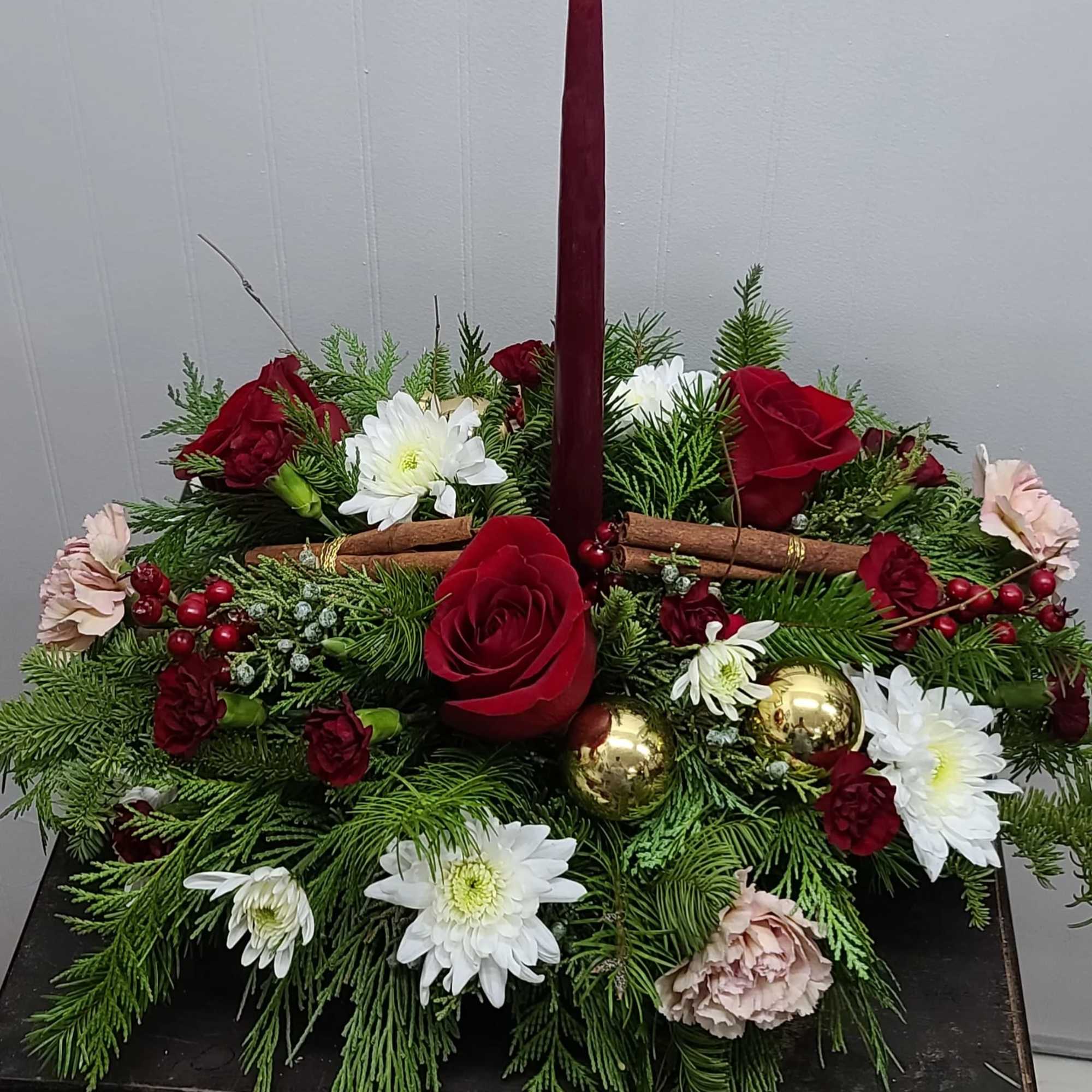 Lush mixed Christmas Greens, Cinnamon Sticks &amp; a beautiful taper candle bring