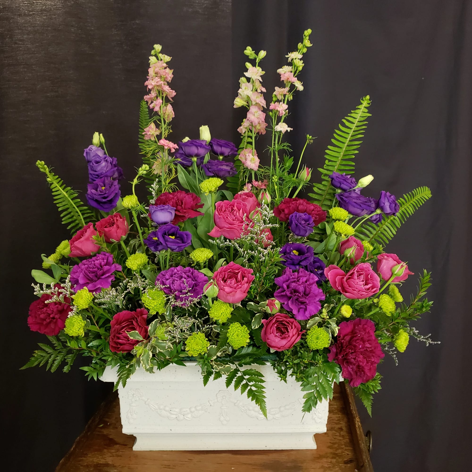 Vibrant Purples and Pinks pop against gorgeous mixed greens. Long lasting carnations