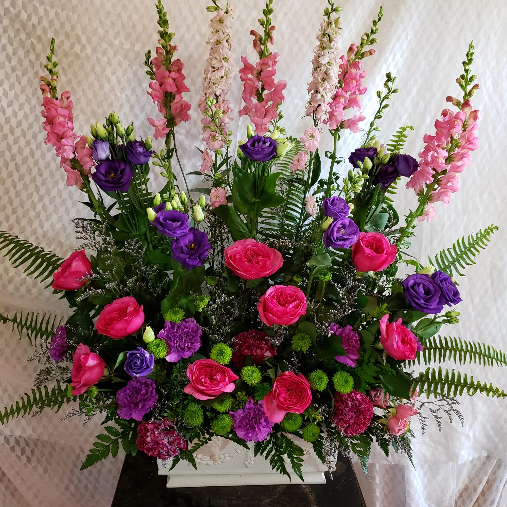 Vibrant Purples and Pinks pop against gorgeous mixed greens. Long lasting carnations