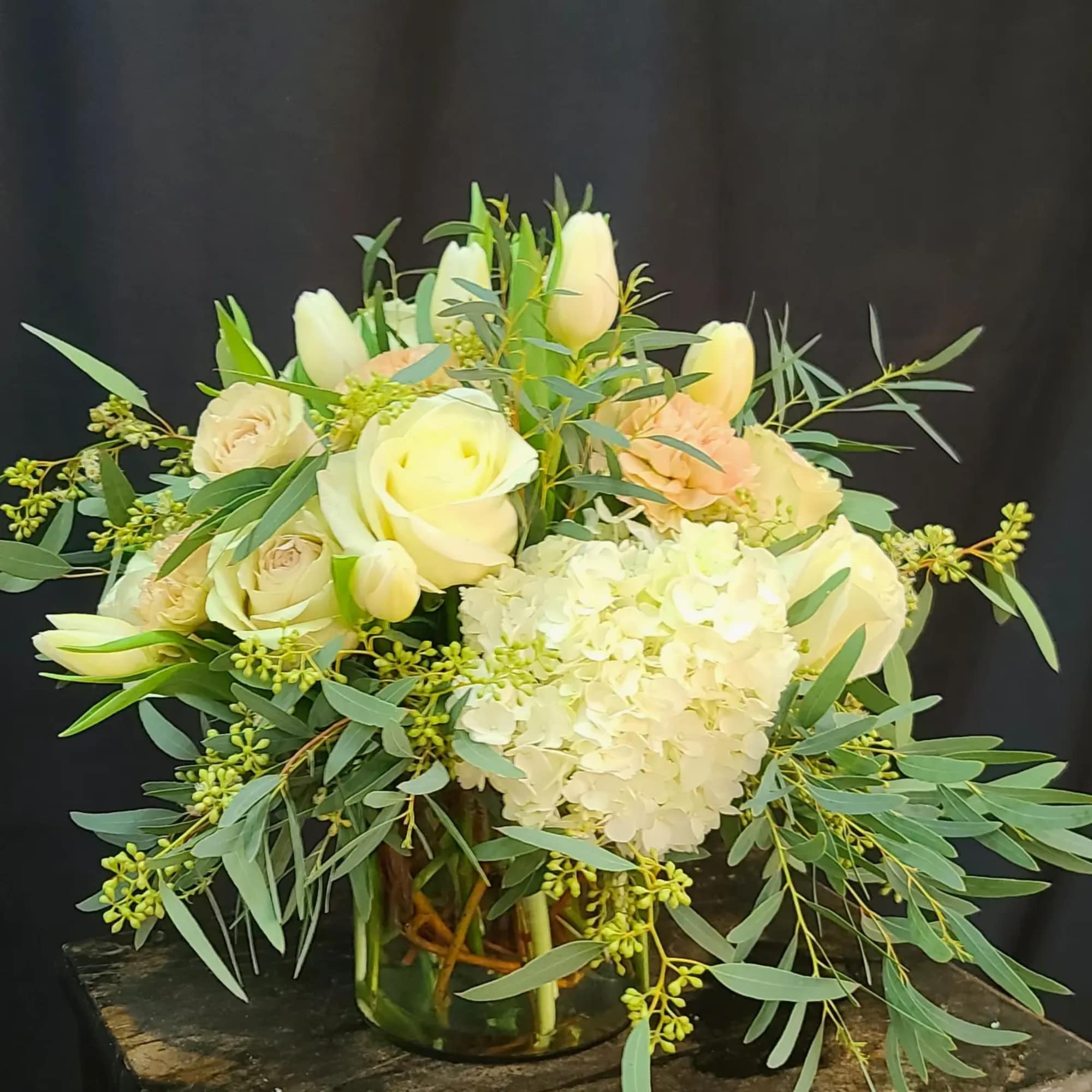 Willow twigs in the vase accent and support the lush hydrangeas, blush