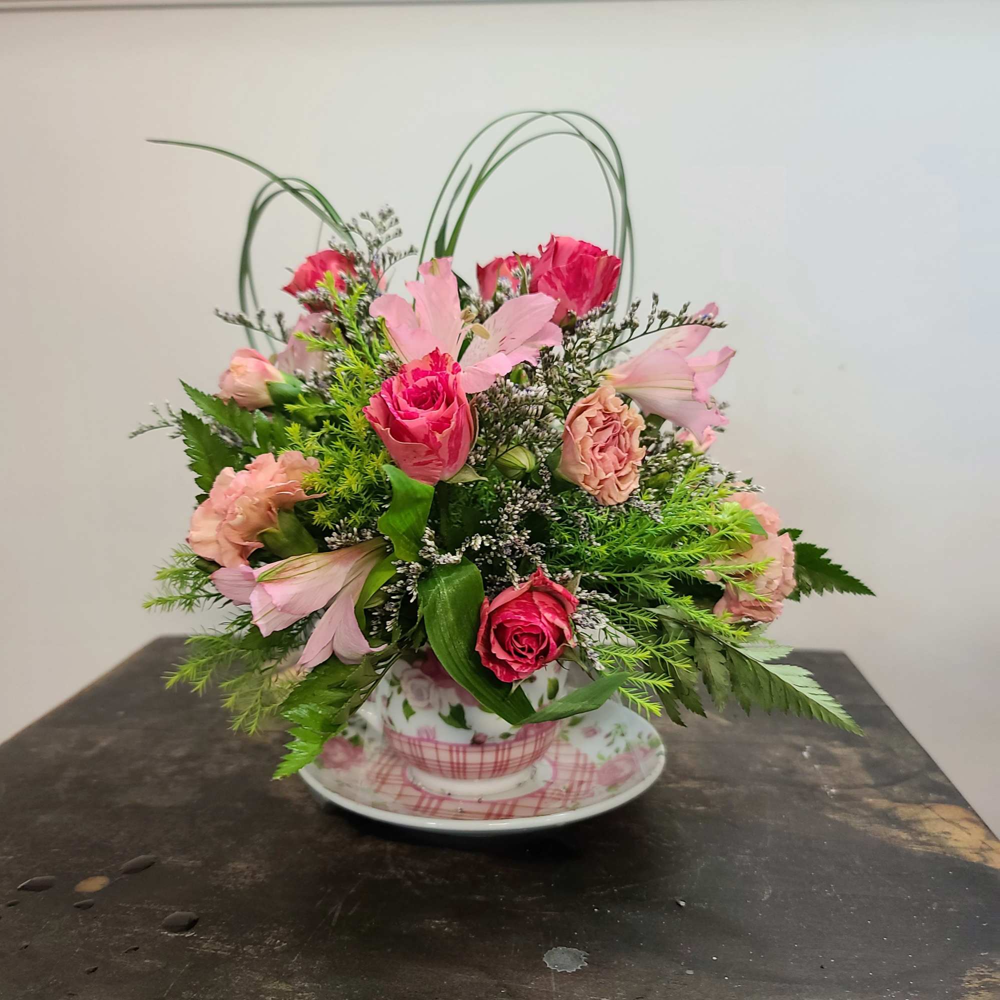 Our signature tea cup arrangement is full of soft shades of pink