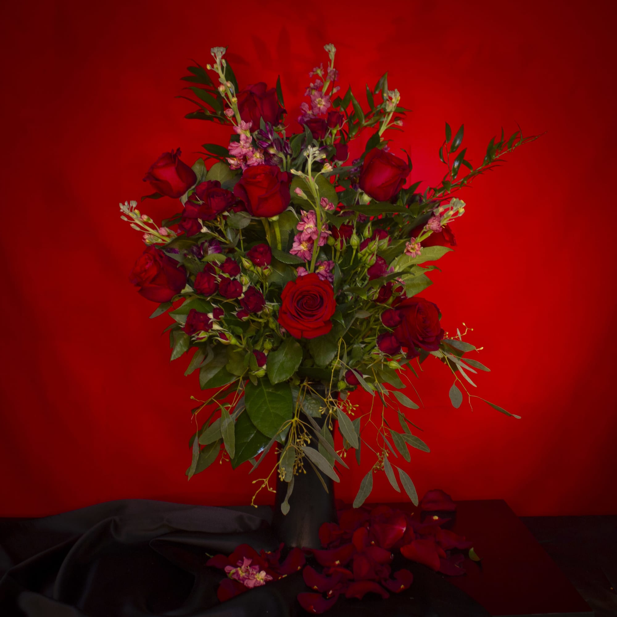 Send 12 Sexy Red roses, artfully arranged in a tall, slender glossy