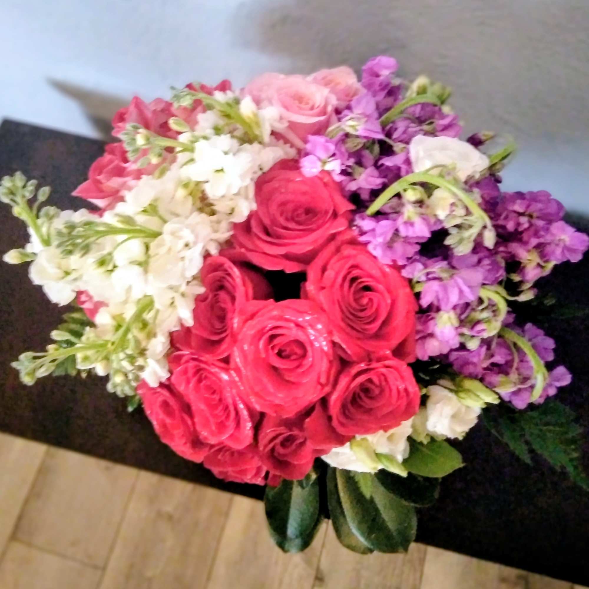 This arrangement has it all. Lots of bright hot pink roses, fragrant