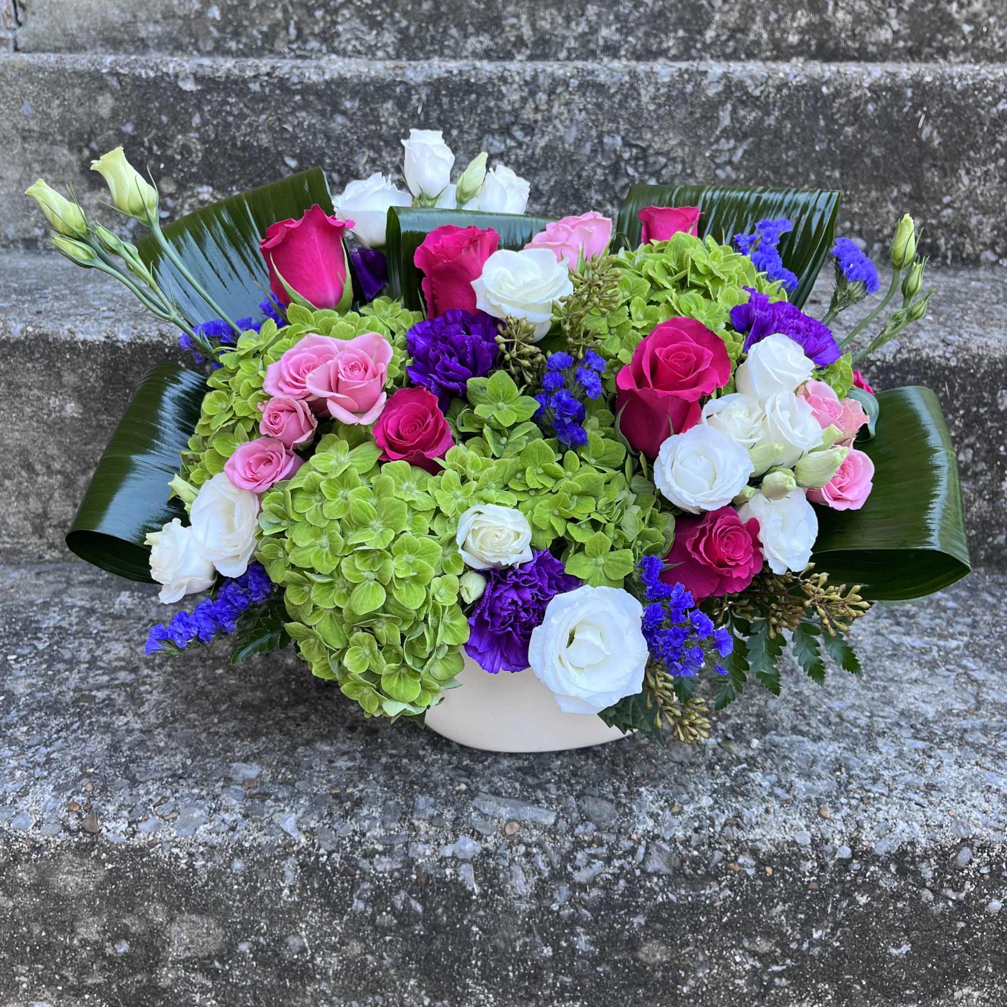 This arrangement has hydrangea, roses, lisianthus, carnations, static and beautiful greenery. 