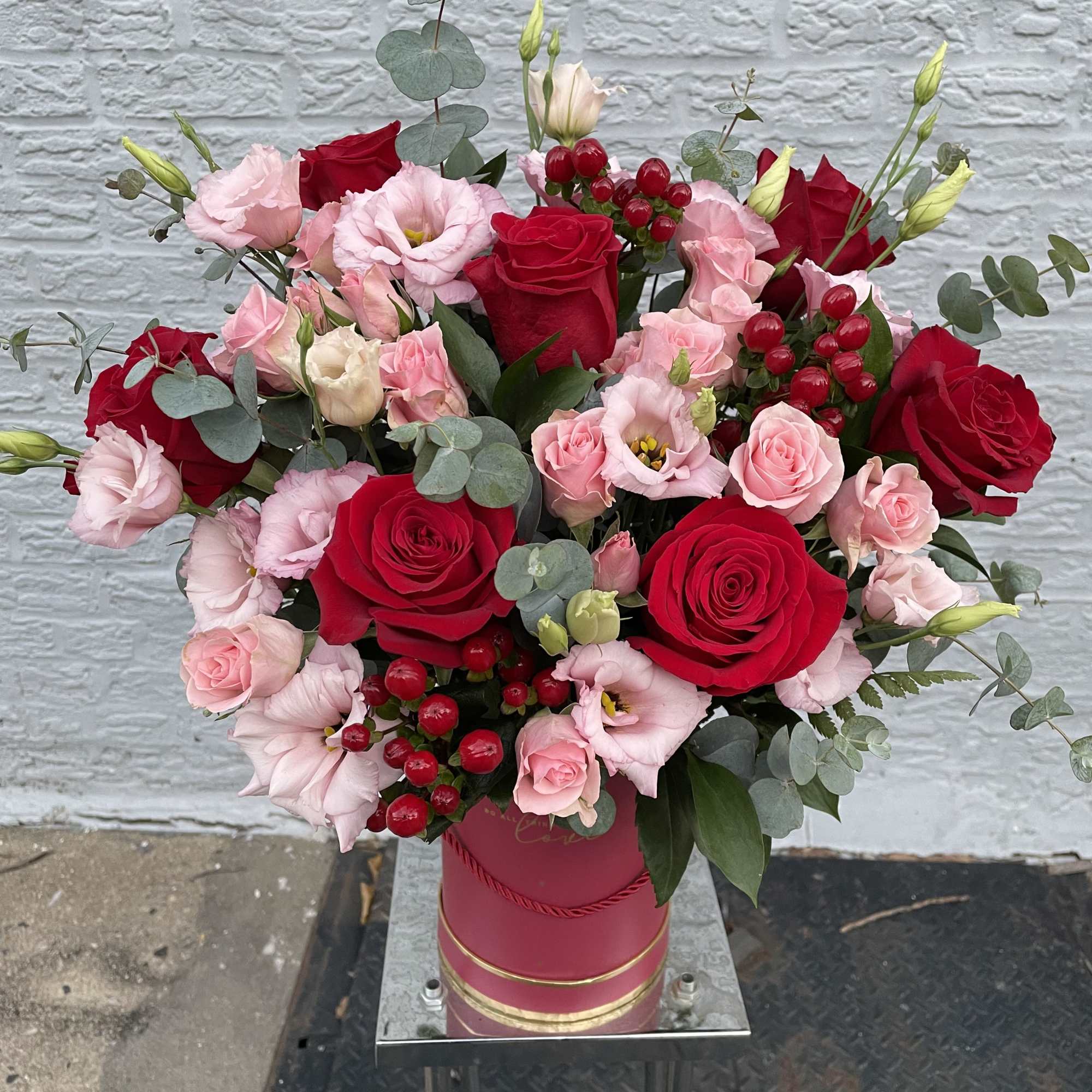 Created with red roses, complemented by delicate lisianthus and spray roses, beautifully
