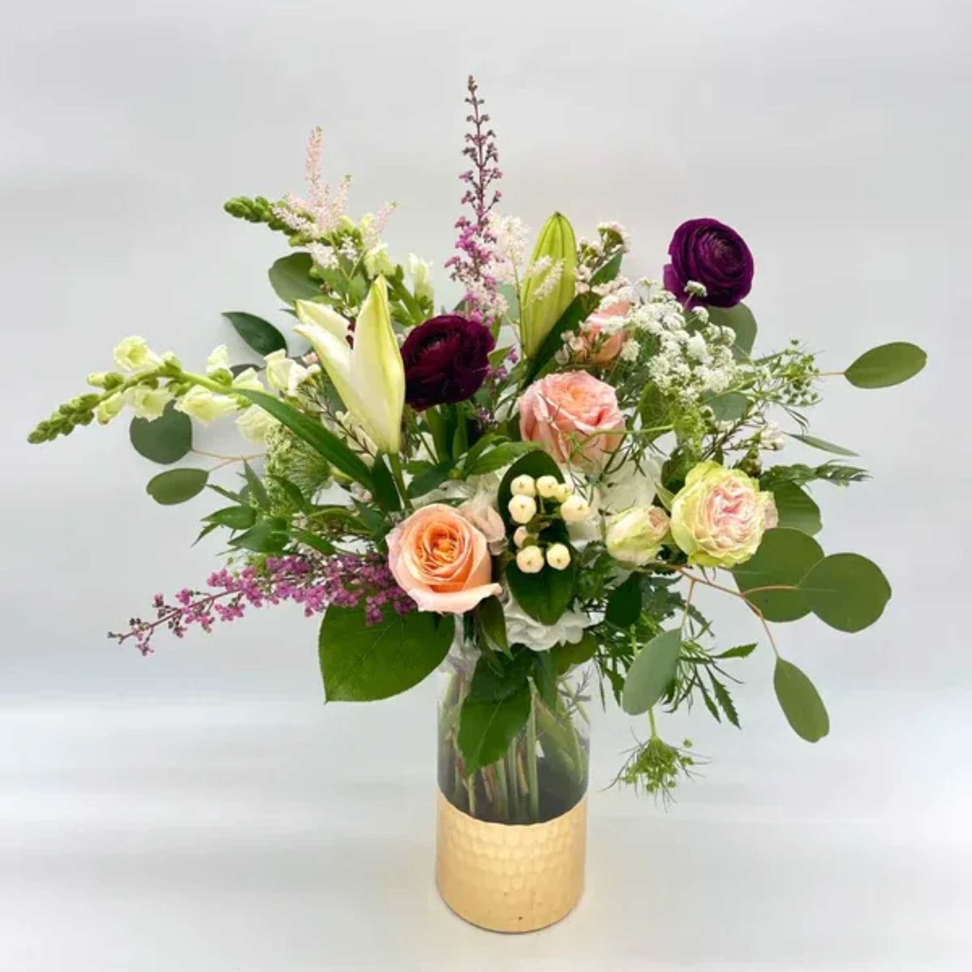 Sweet and romantic, tall, garden-style arrangement with a mix of soft peaches