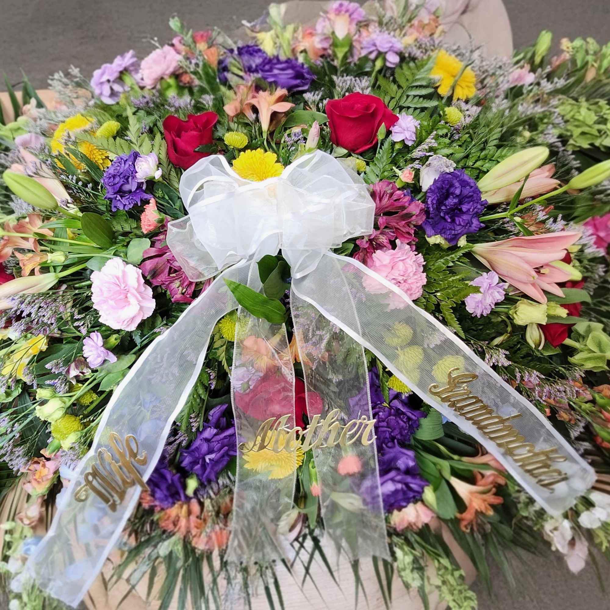 This is a lush, XL half casket spray designed to honor a