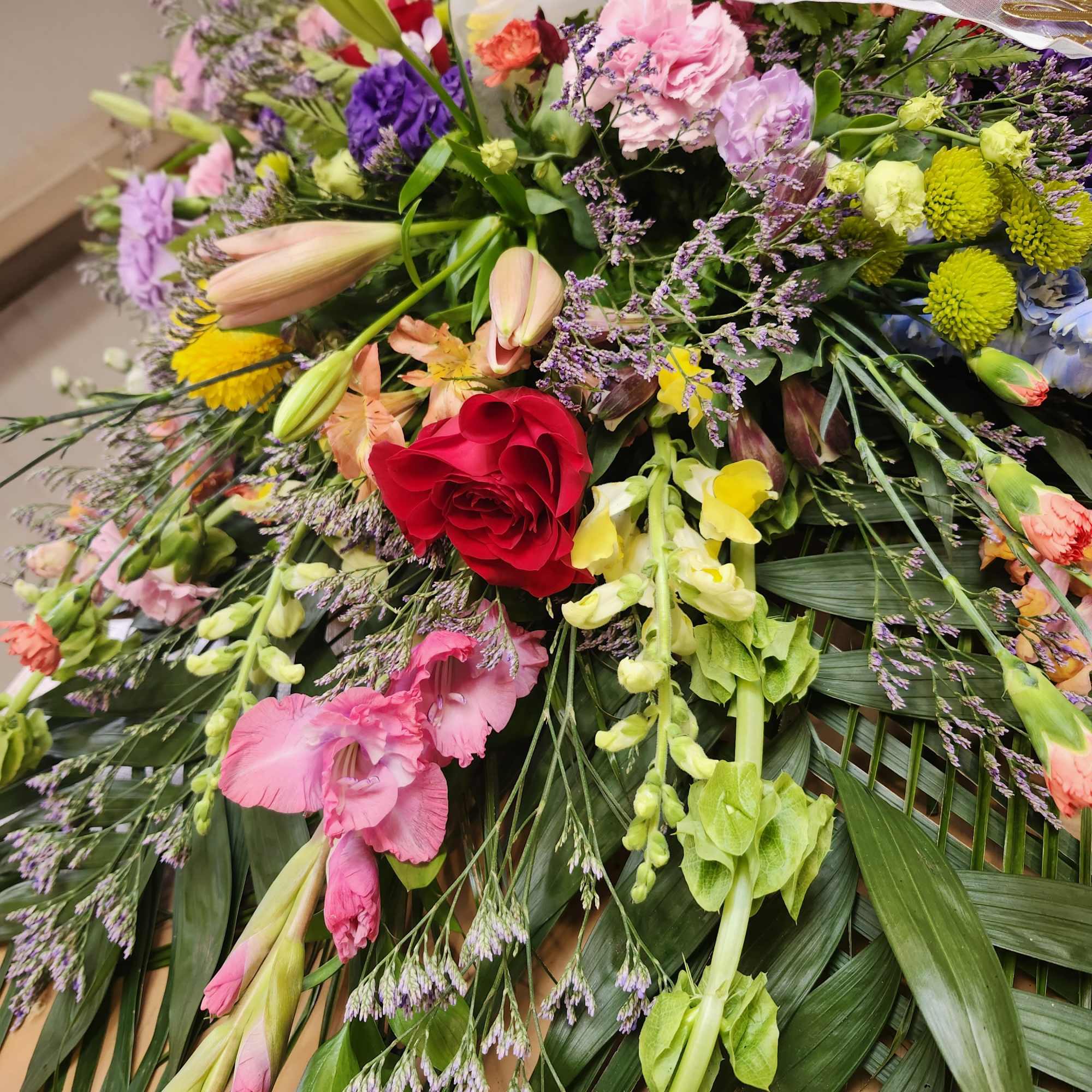 This is a lush, XL half casket spray designed to honor a