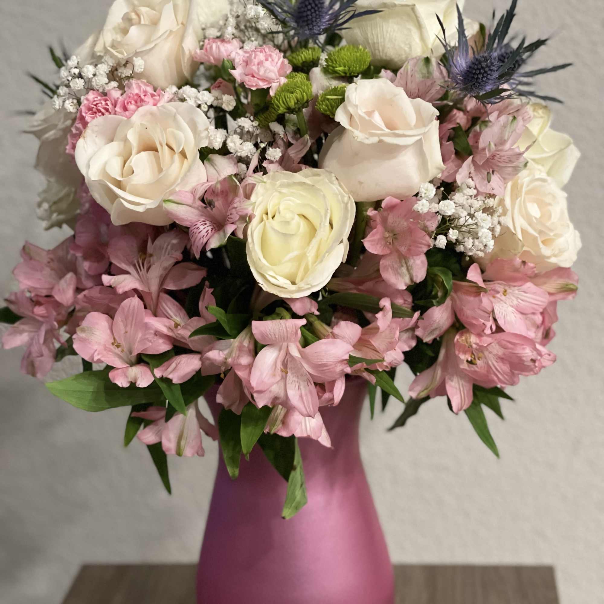 Lovely floral arrangement of long stem white roses, pink alstroemerias, baby&rsquo;s breath
