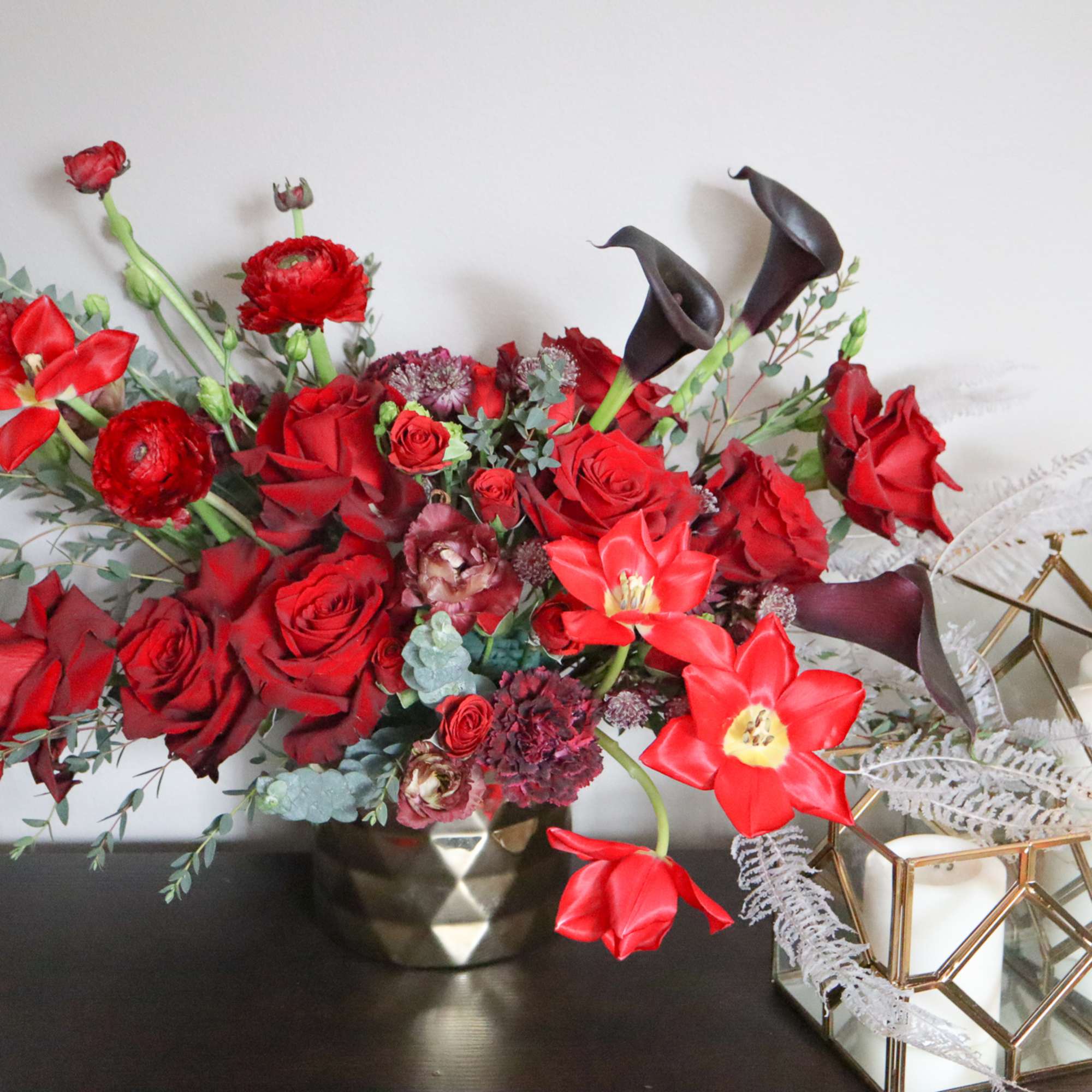 Elegant and irresistible this beautiful arrangement of  red roses, red ranunculus
