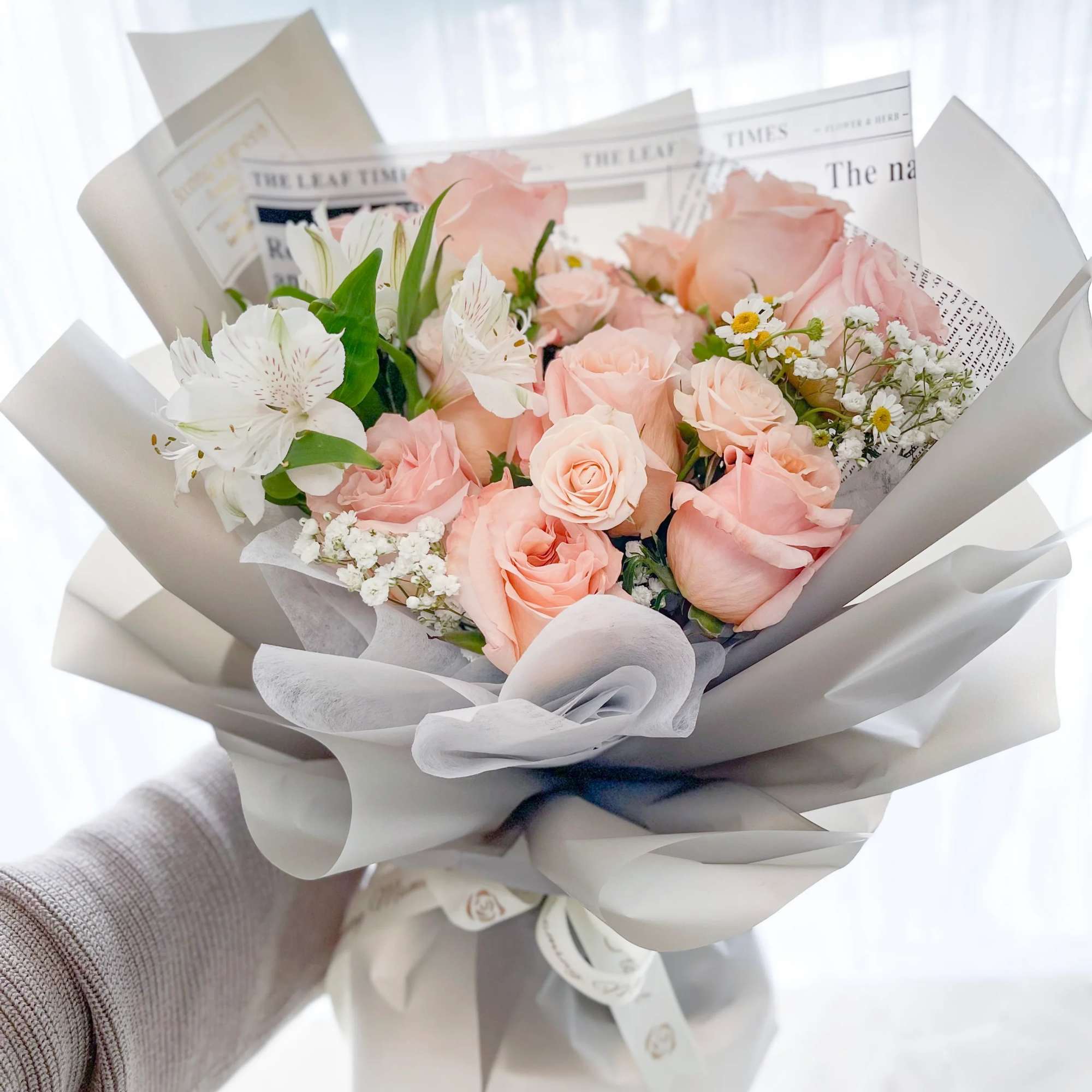 Pink peach rose with seasonal florist pick white flowers wrapped with light