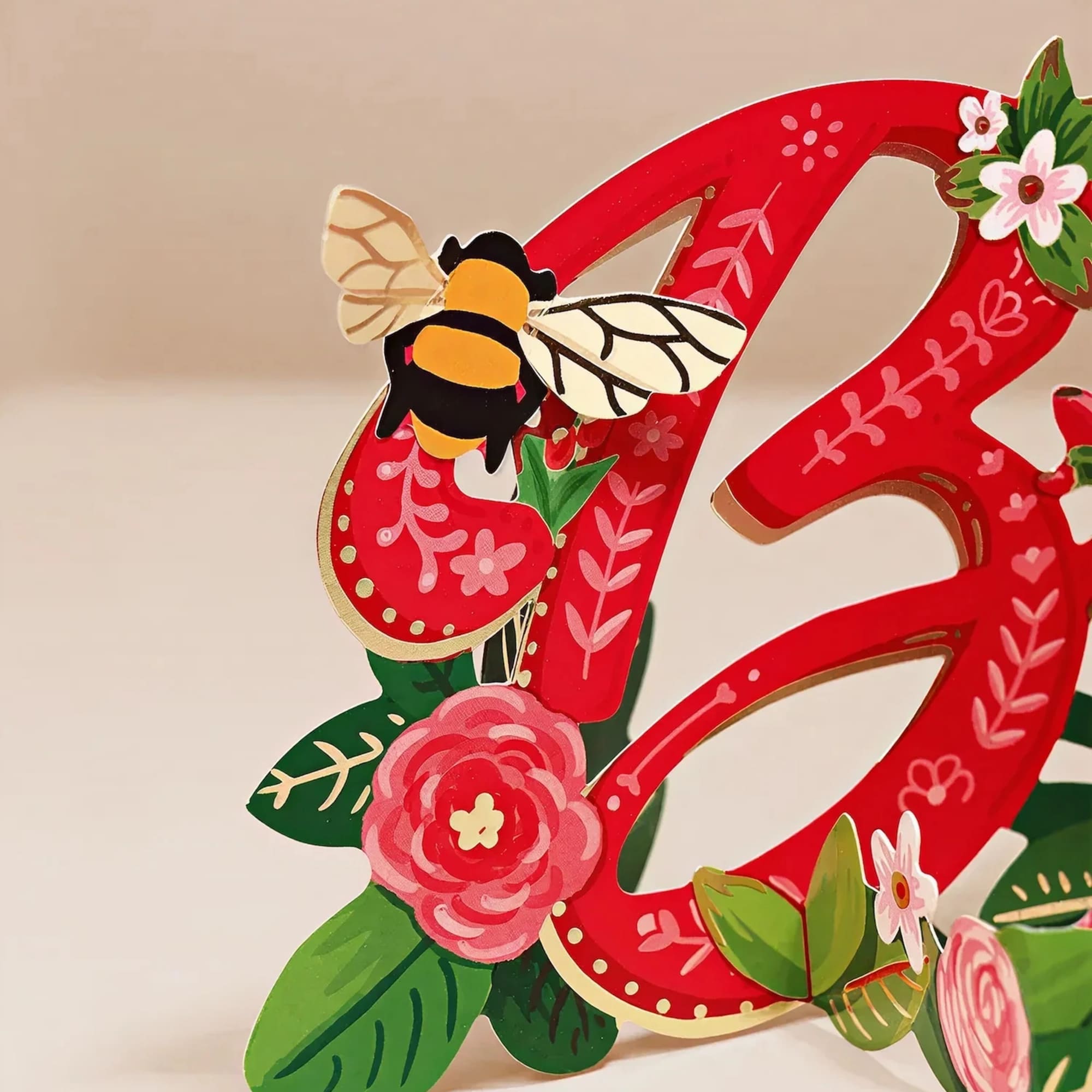 Shining with gold foil and sprouting with pink and red roses and