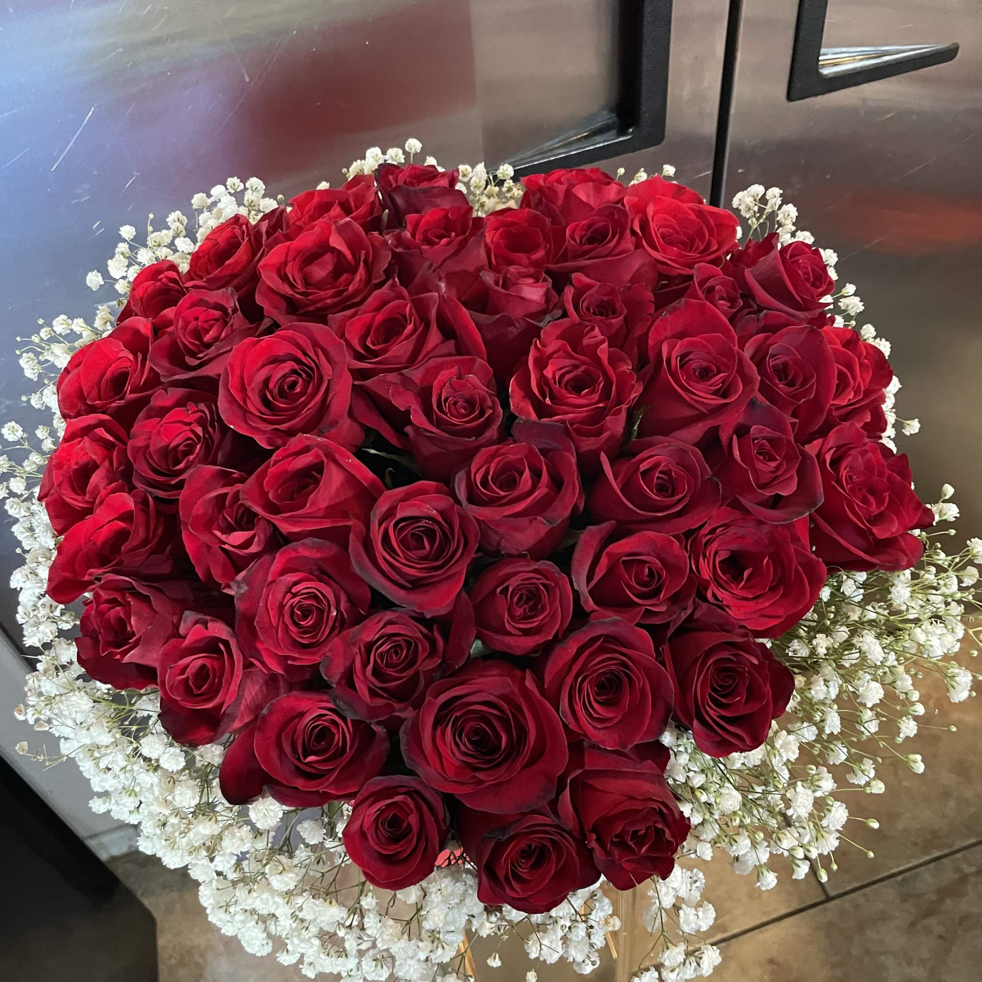 50 red roses in a heart shaped box trimmed on baby&rsquo;s breath