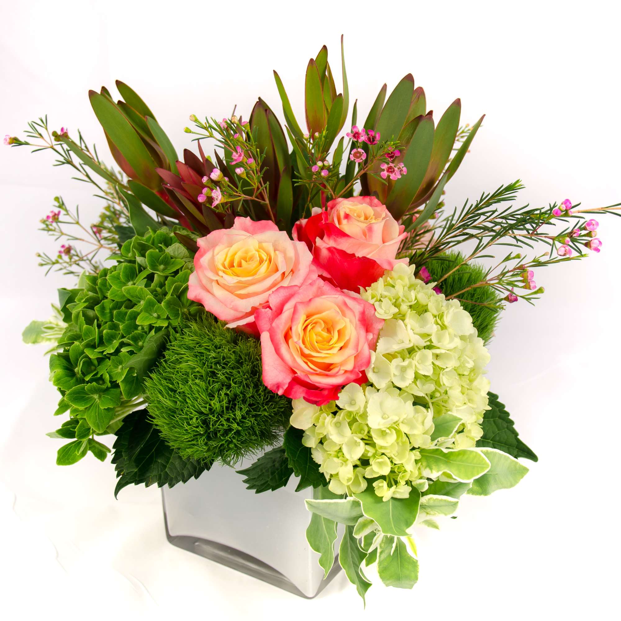 Bright and colorful arrangement, low compact design in white cubed vase. Cheer