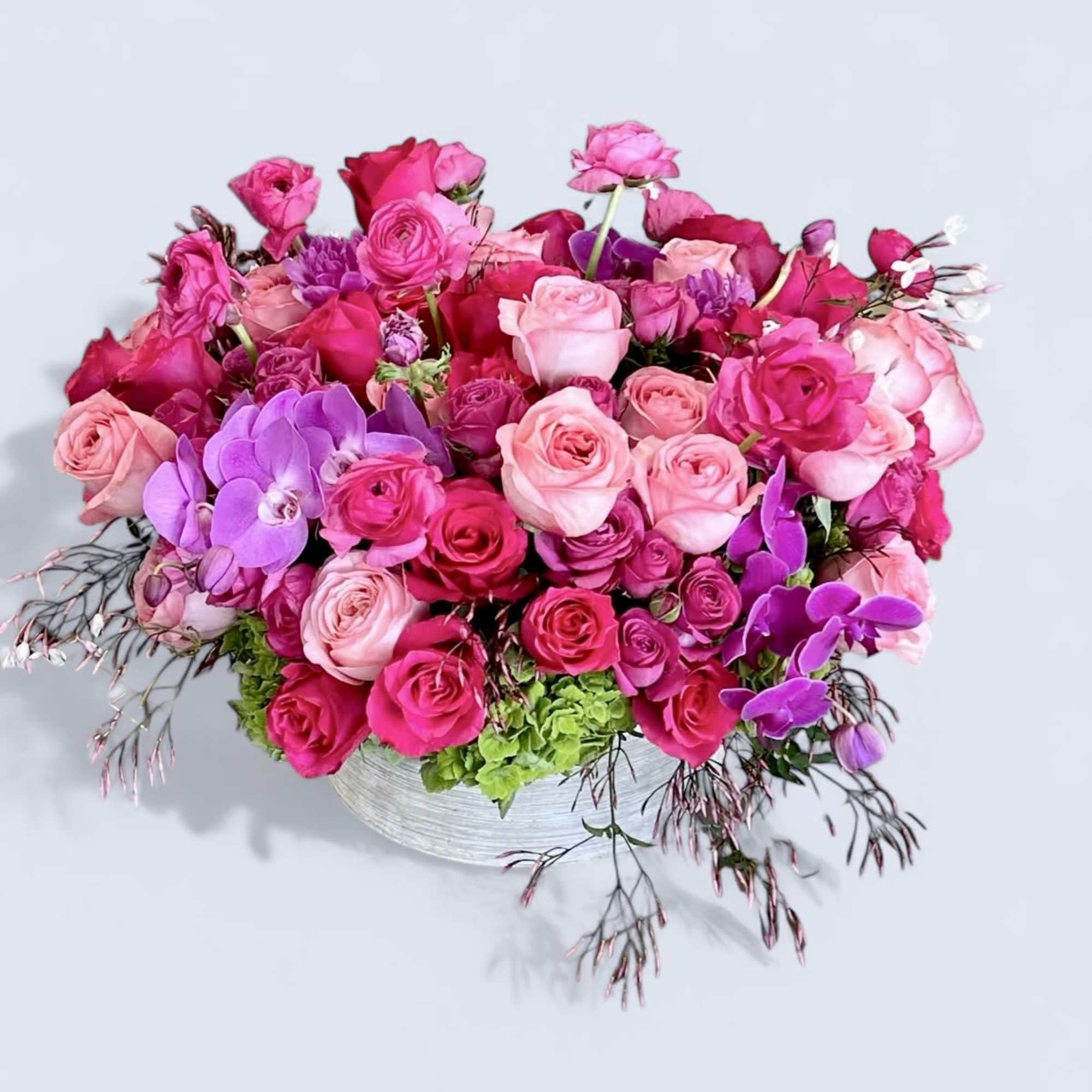 A variety of pink Roses, with Ranunculus, and Phalaenopsis Orchids