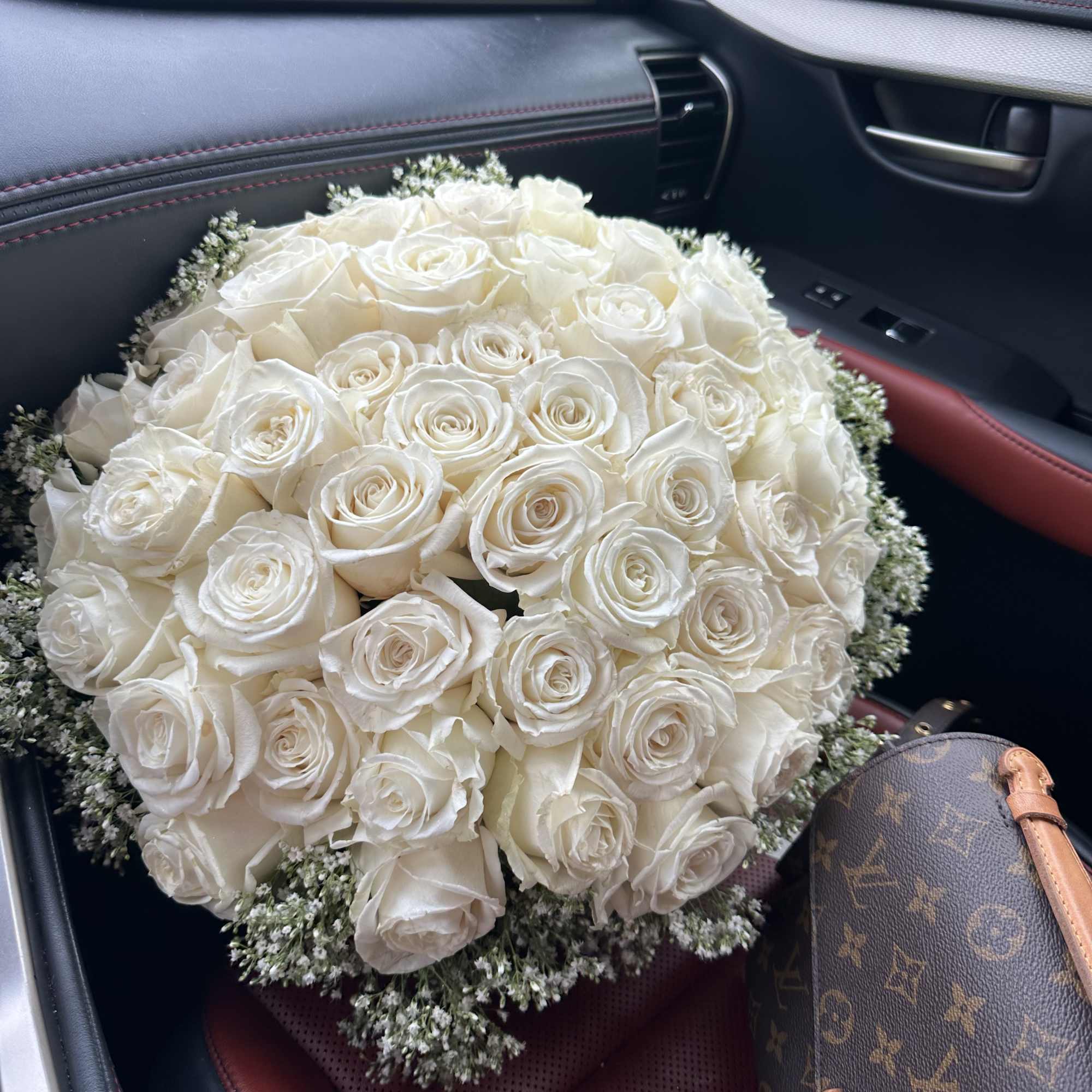 A romantic composition of 50 Roses ,artfully gathered into a perfect round