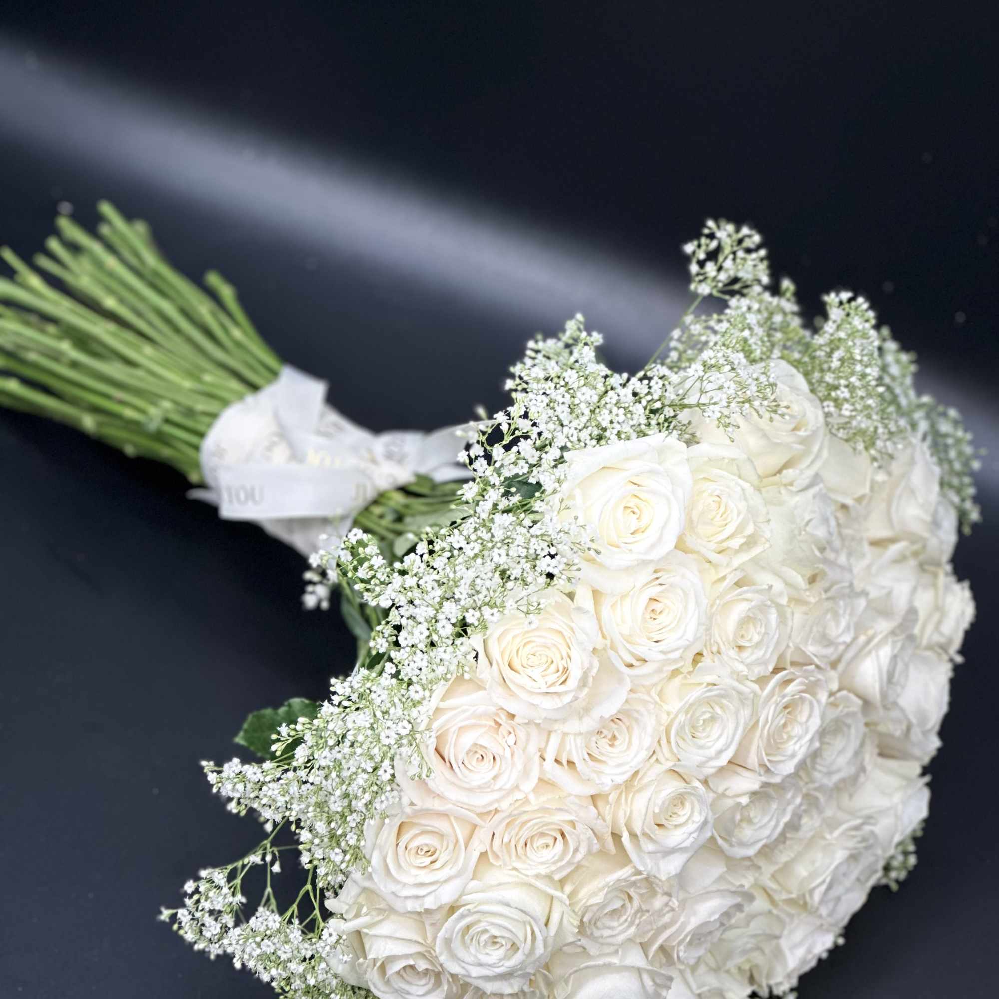 A romantic composition of 50 Roses ,artfully gathered into a perfect round