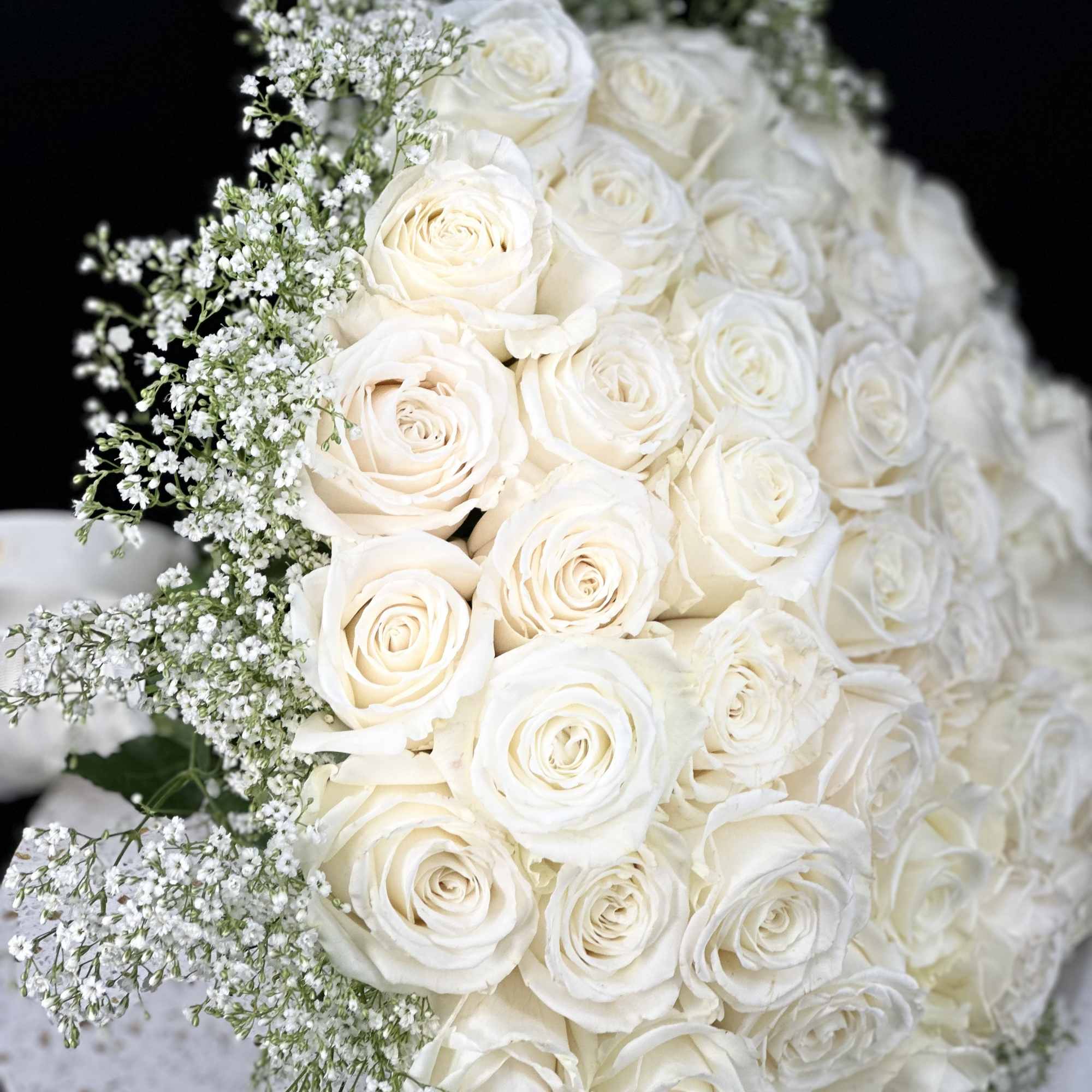 A romantic composition of 50 Roses ,artfully gathered into a perfect round