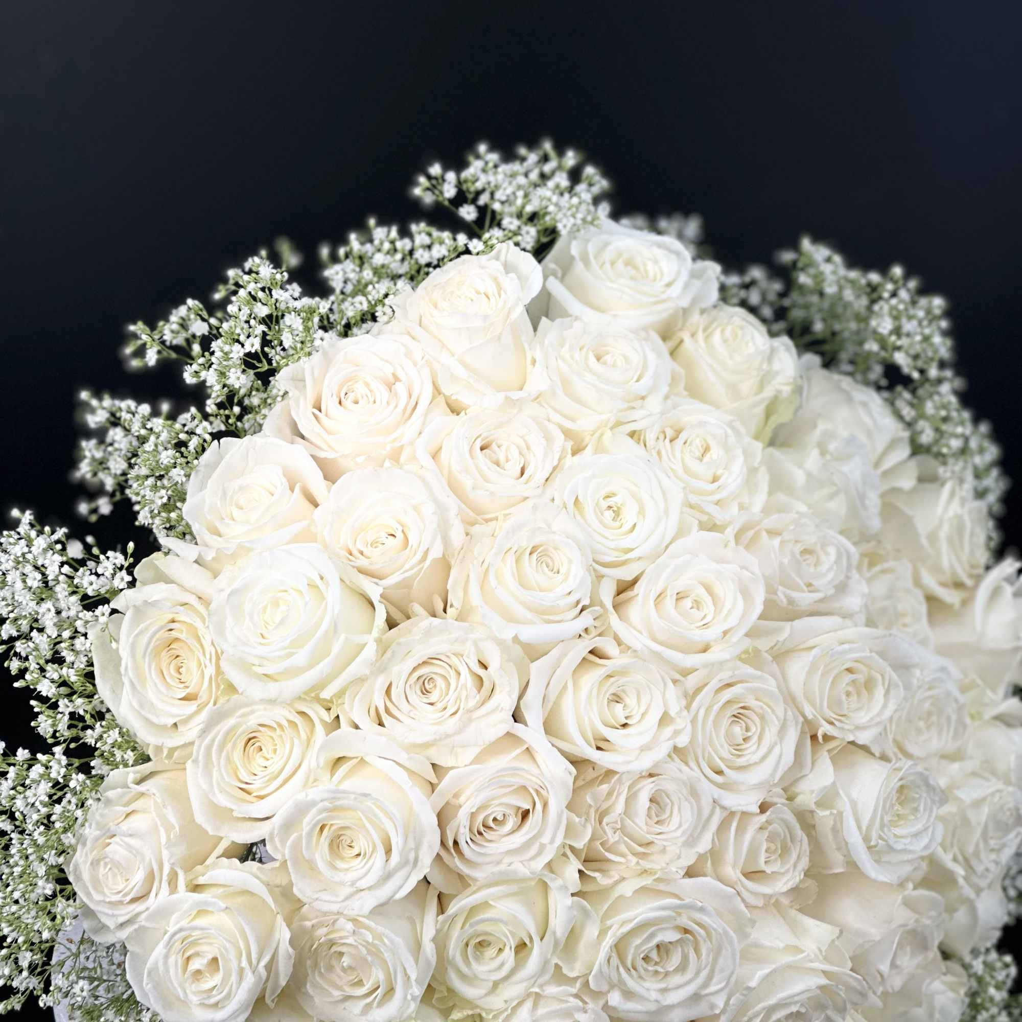 A romantic composition of 50 Roses ,artfully gathered into a perfect round
