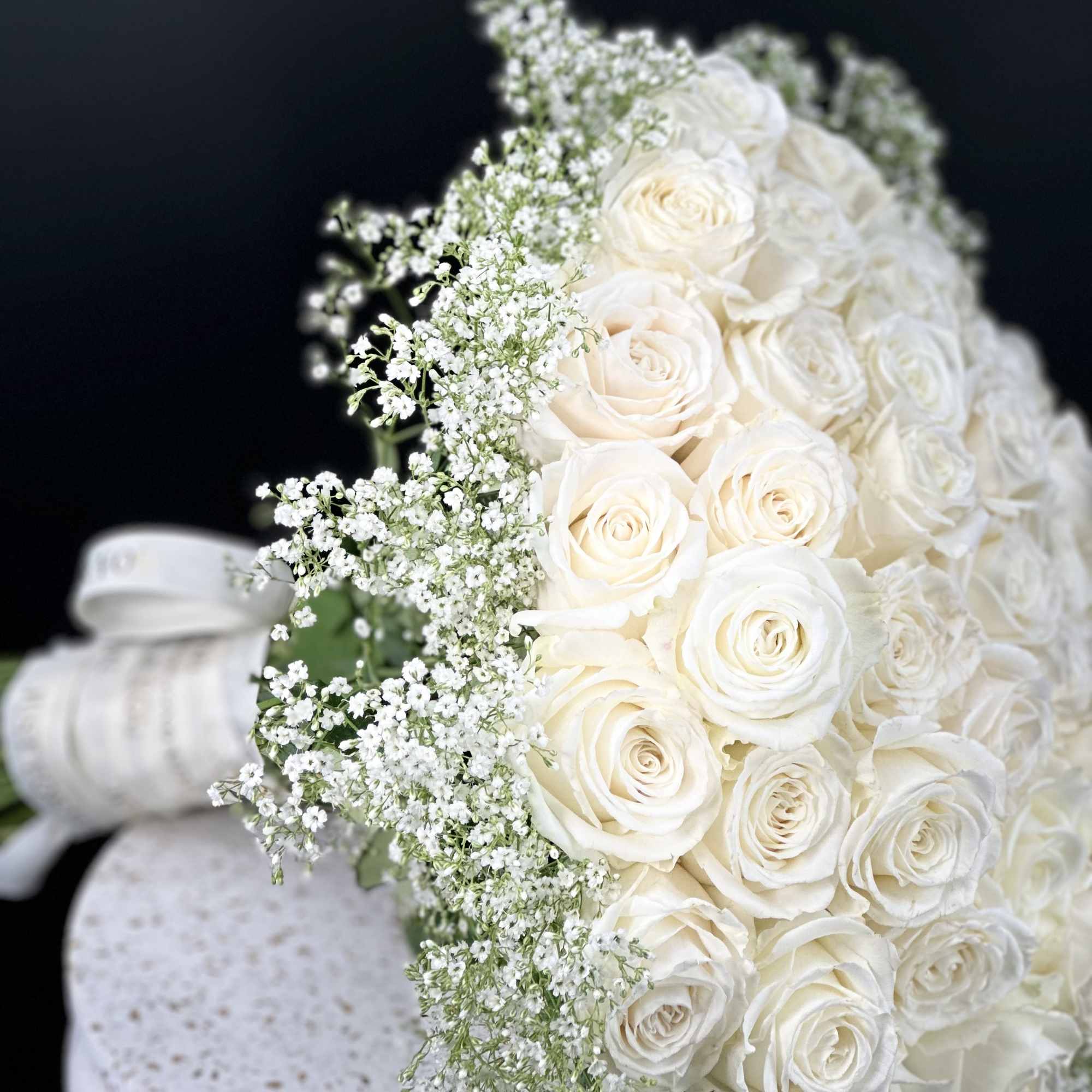 A romantic composition of 50 Roses ,artfully gathered into a perfect round