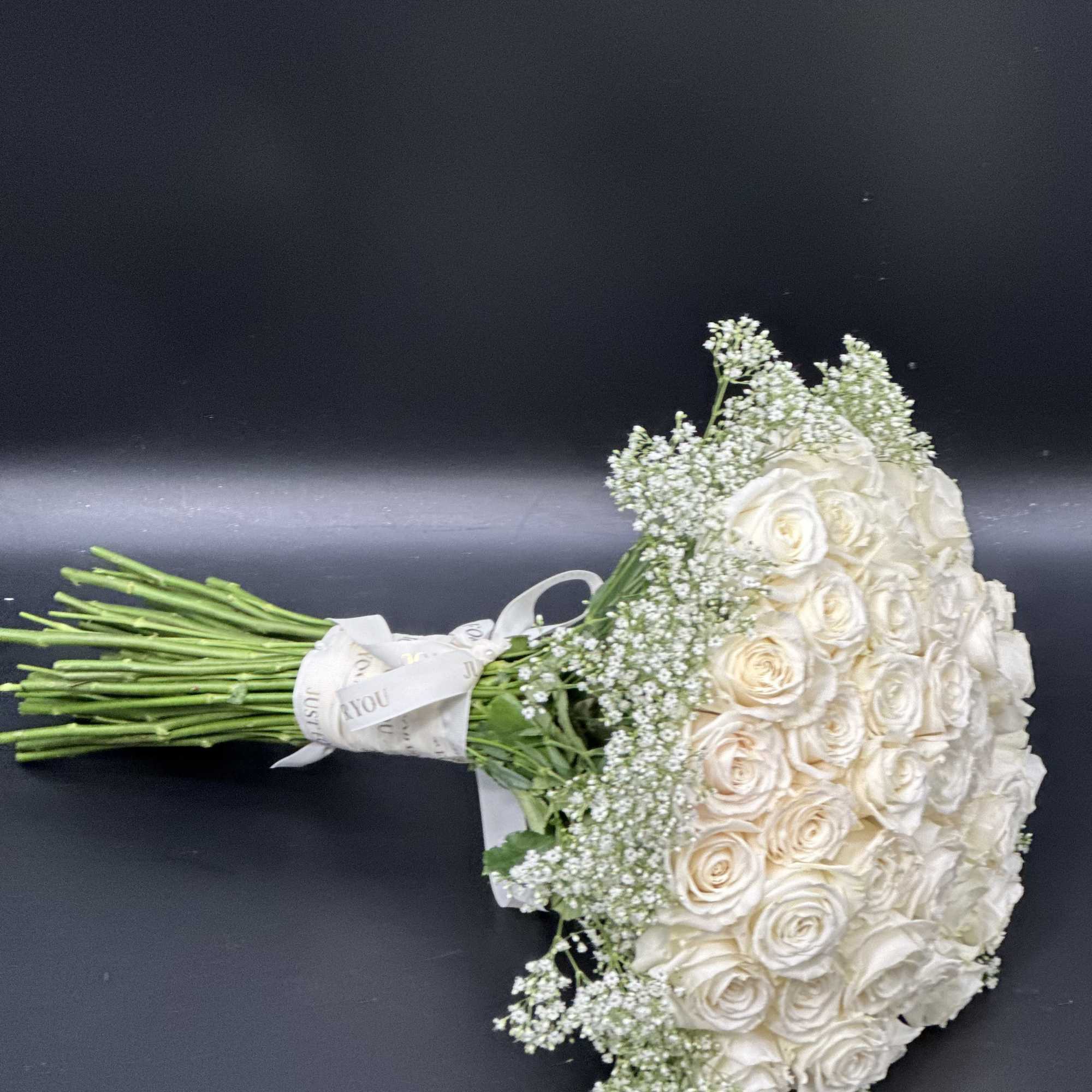 A romantic composition of 50 Roses ,artfully gathered into a perfect round