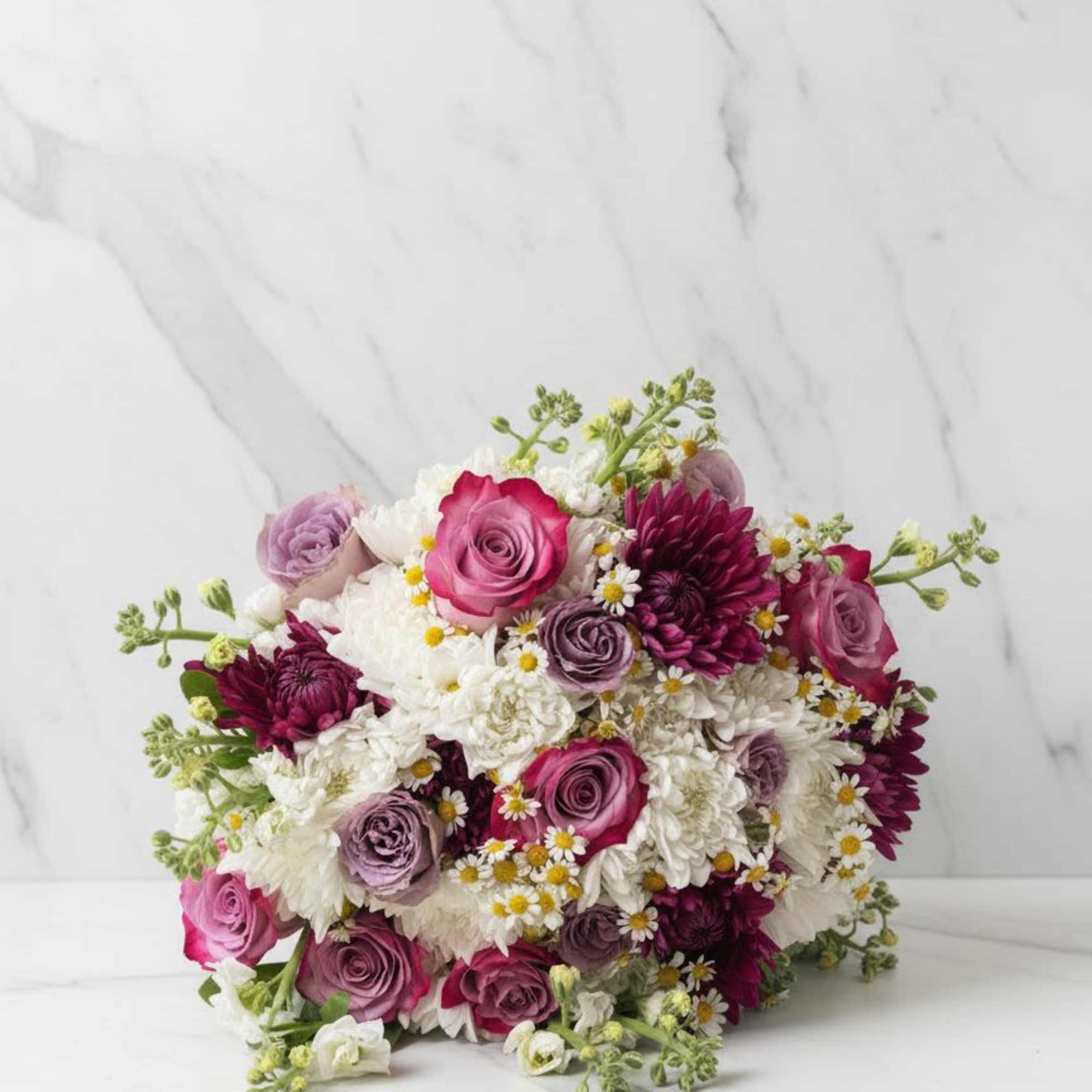 A beautifully wrapped bouquet that&rsquo;s filled with blooms in a color palette