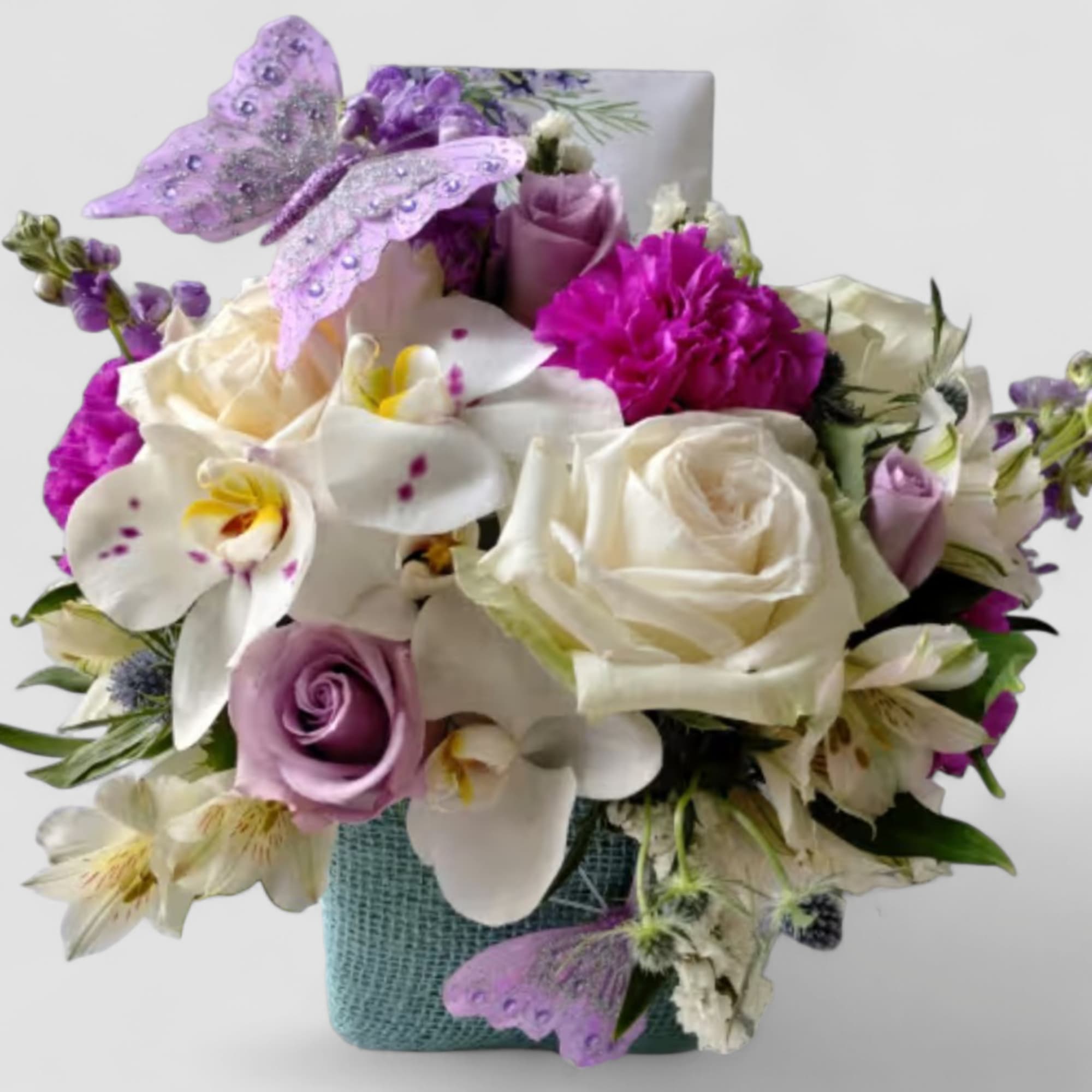 Lovely roses orchids and more arranged in a modern glass cube vase