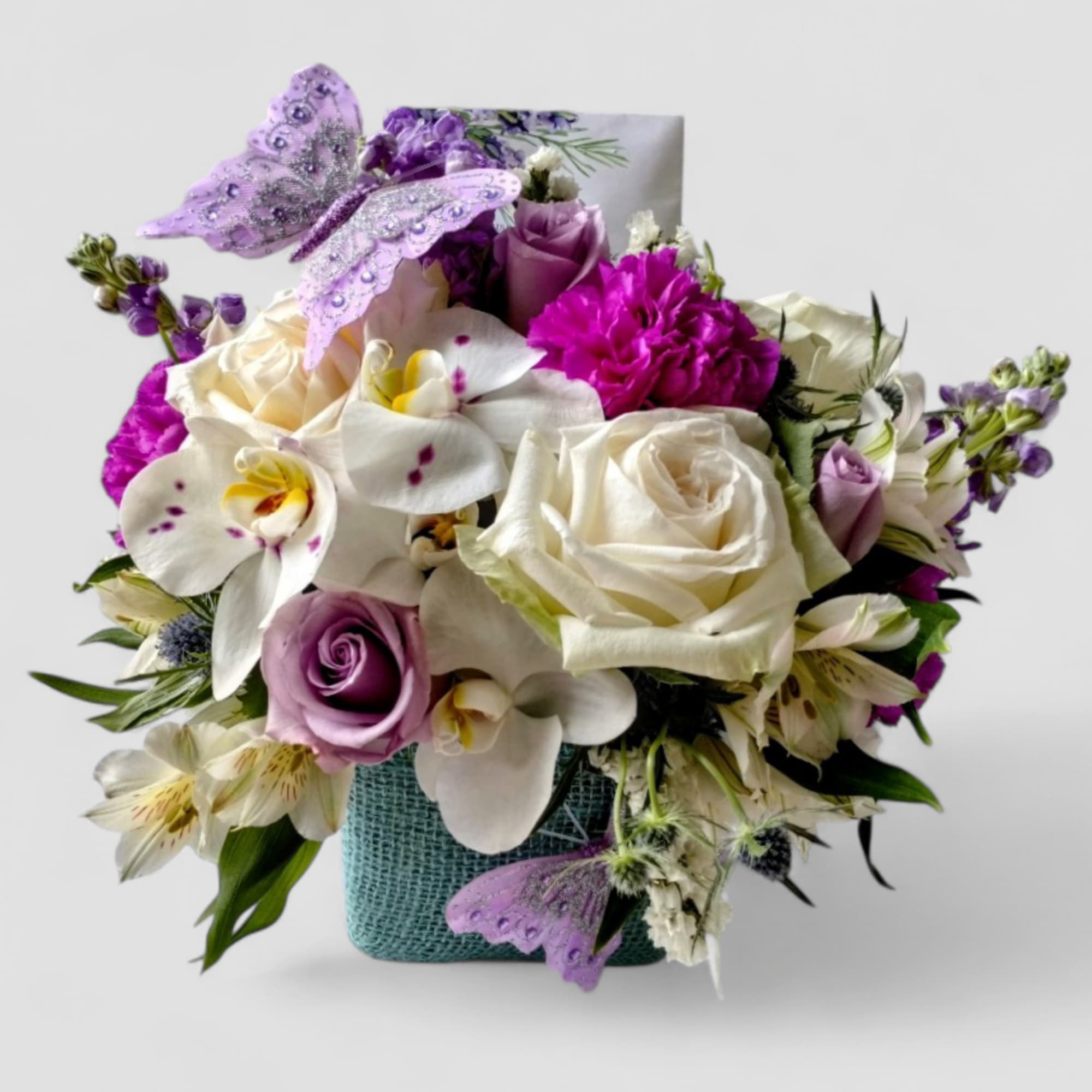 Lovely roses orchids and more arranged in a modern glass cube vase