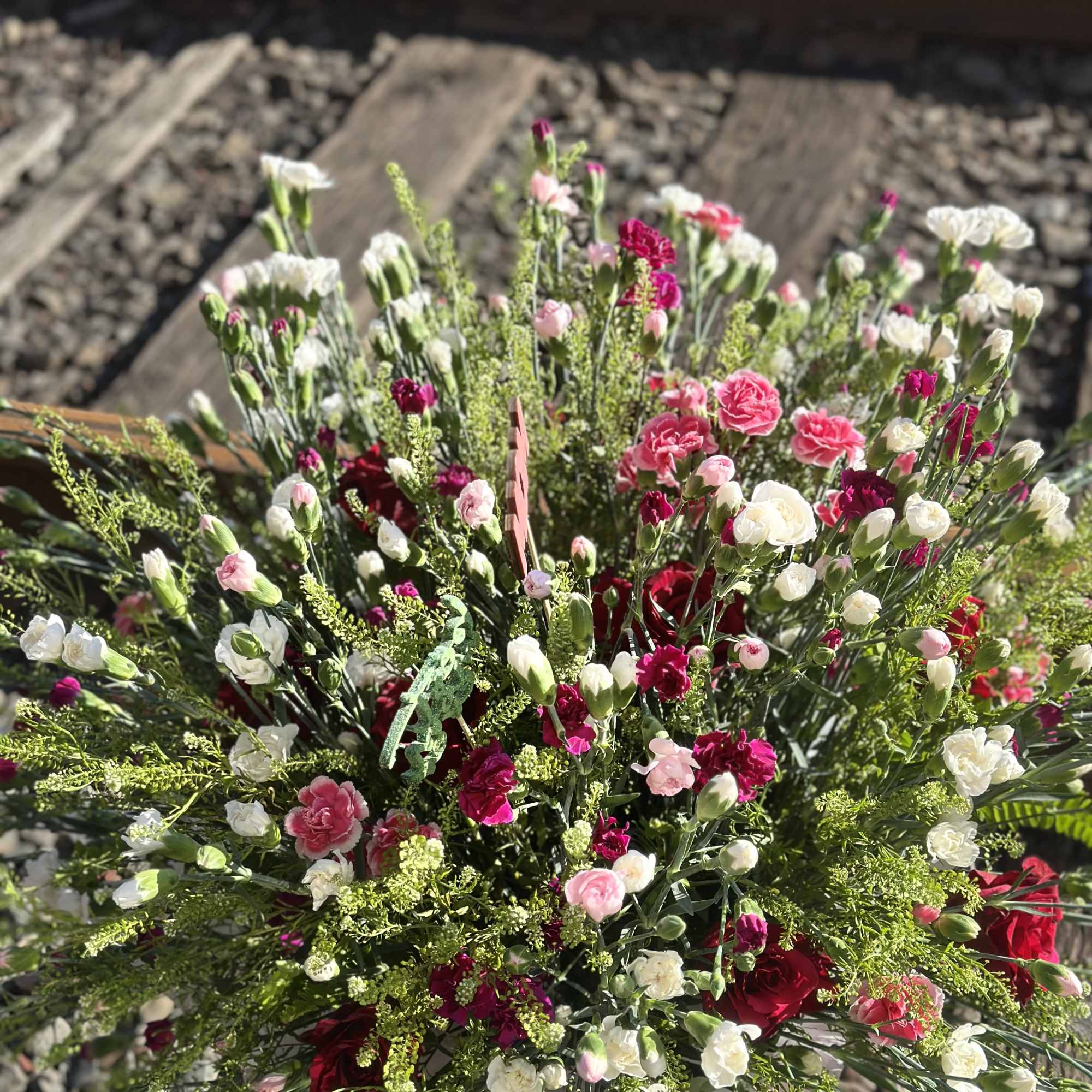 This arrangement is a full , mix carnation ,with greenery  garden