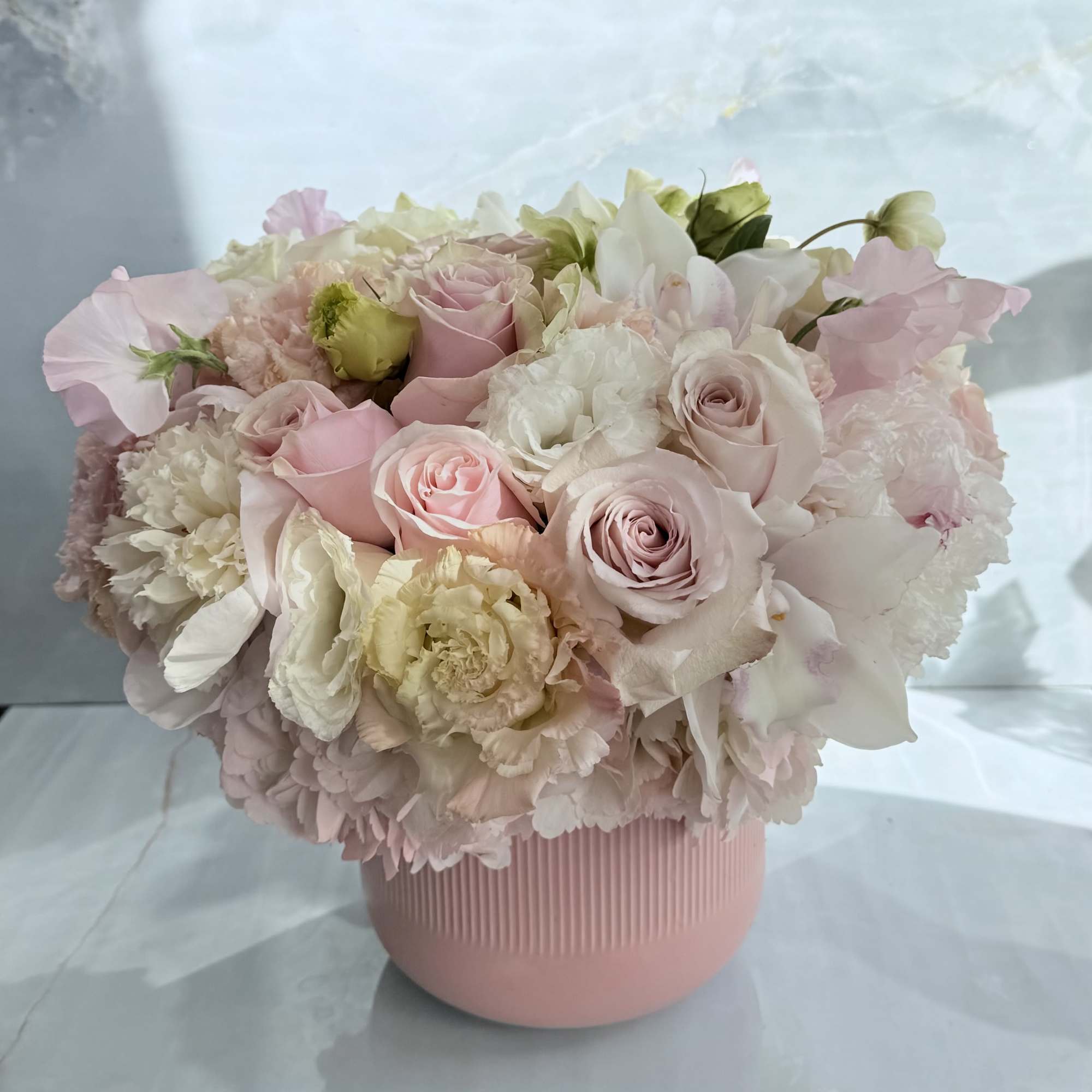 This floral arrangement is soft, romantic, and garden-inspired, featuring a lush blend