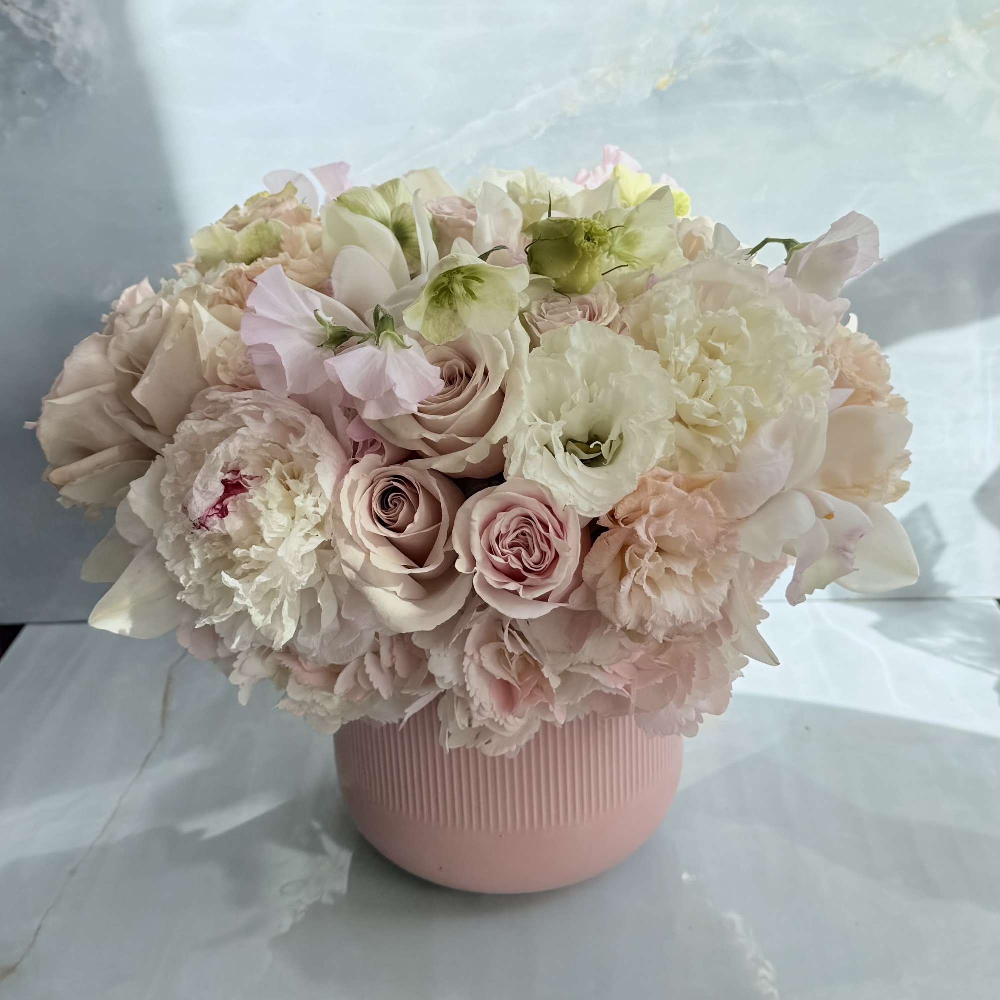 This floral arrangement is soft, romantic, and garden-inspired, featuring a lush blend
