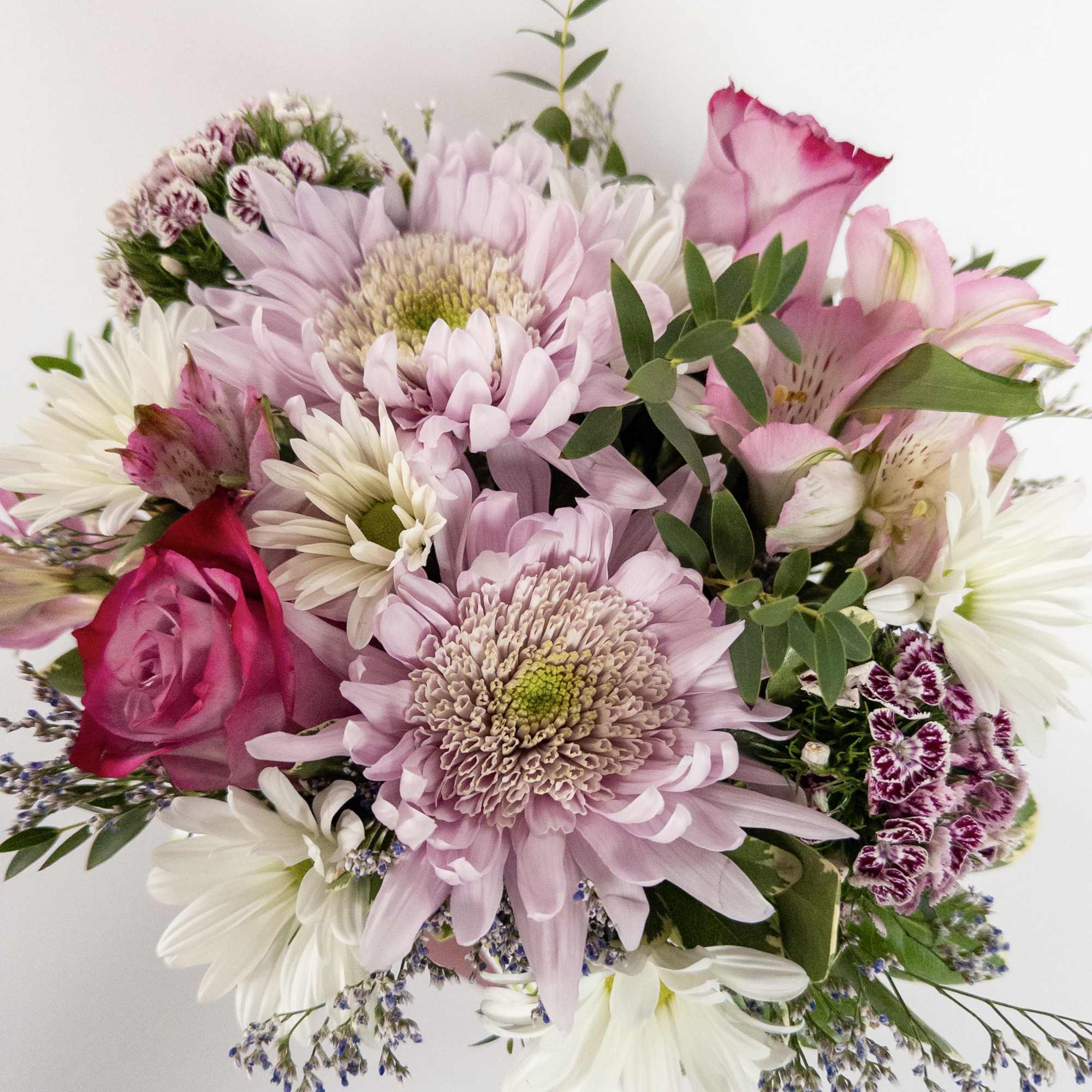 A pink glass cube filled with pink and lavender blooms. 2 lavender