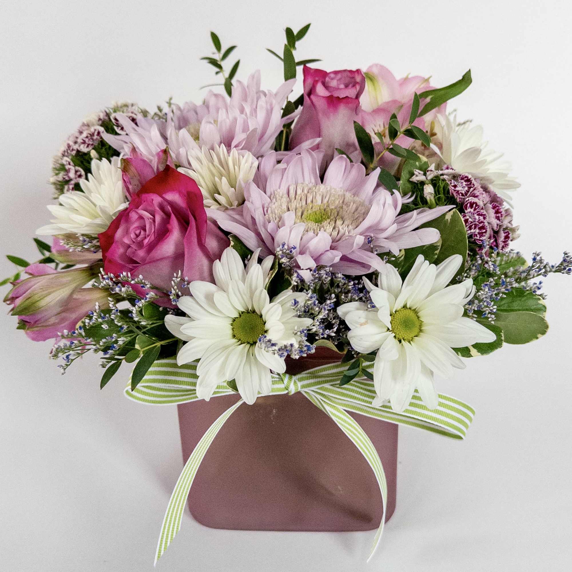 A pink glass cube filled with pink and lavender blooms. 2 lavender