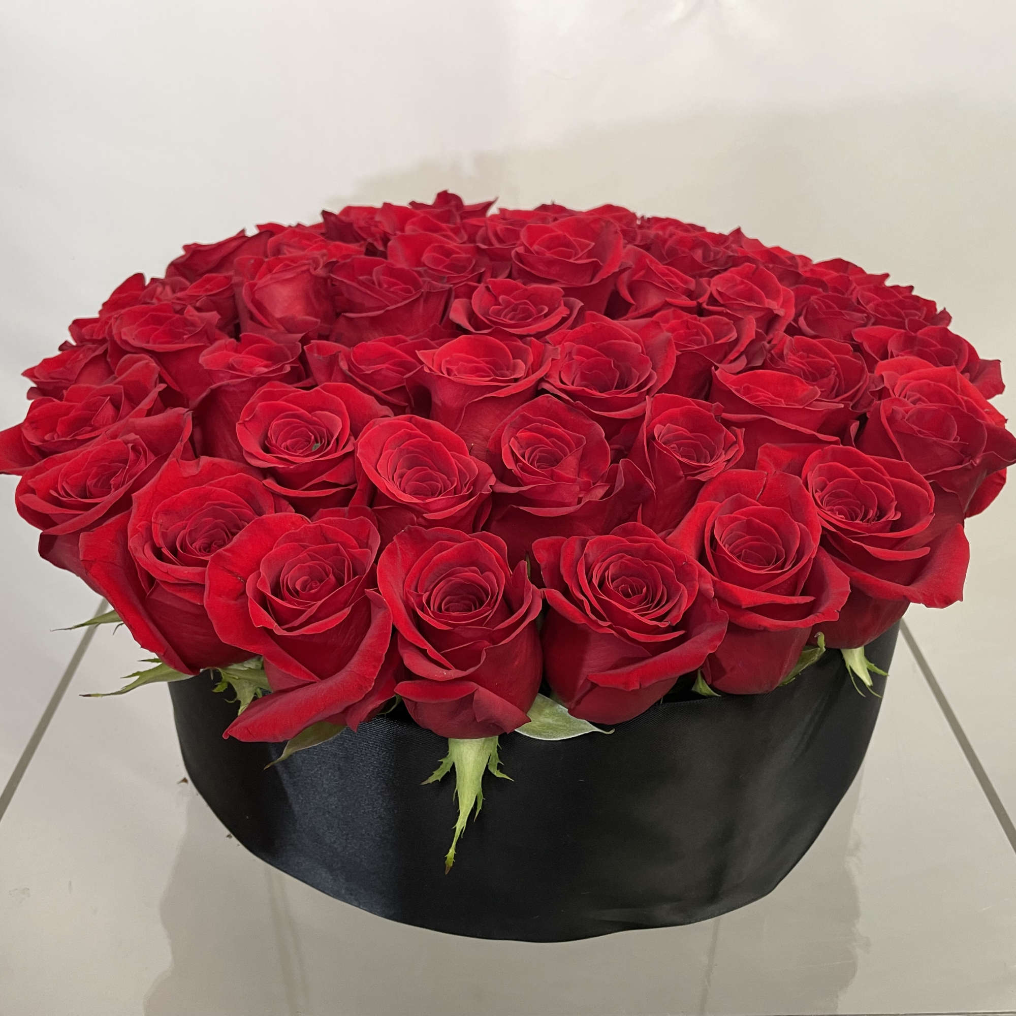 An abundance of red roses in this elegant, tight, compact, high end