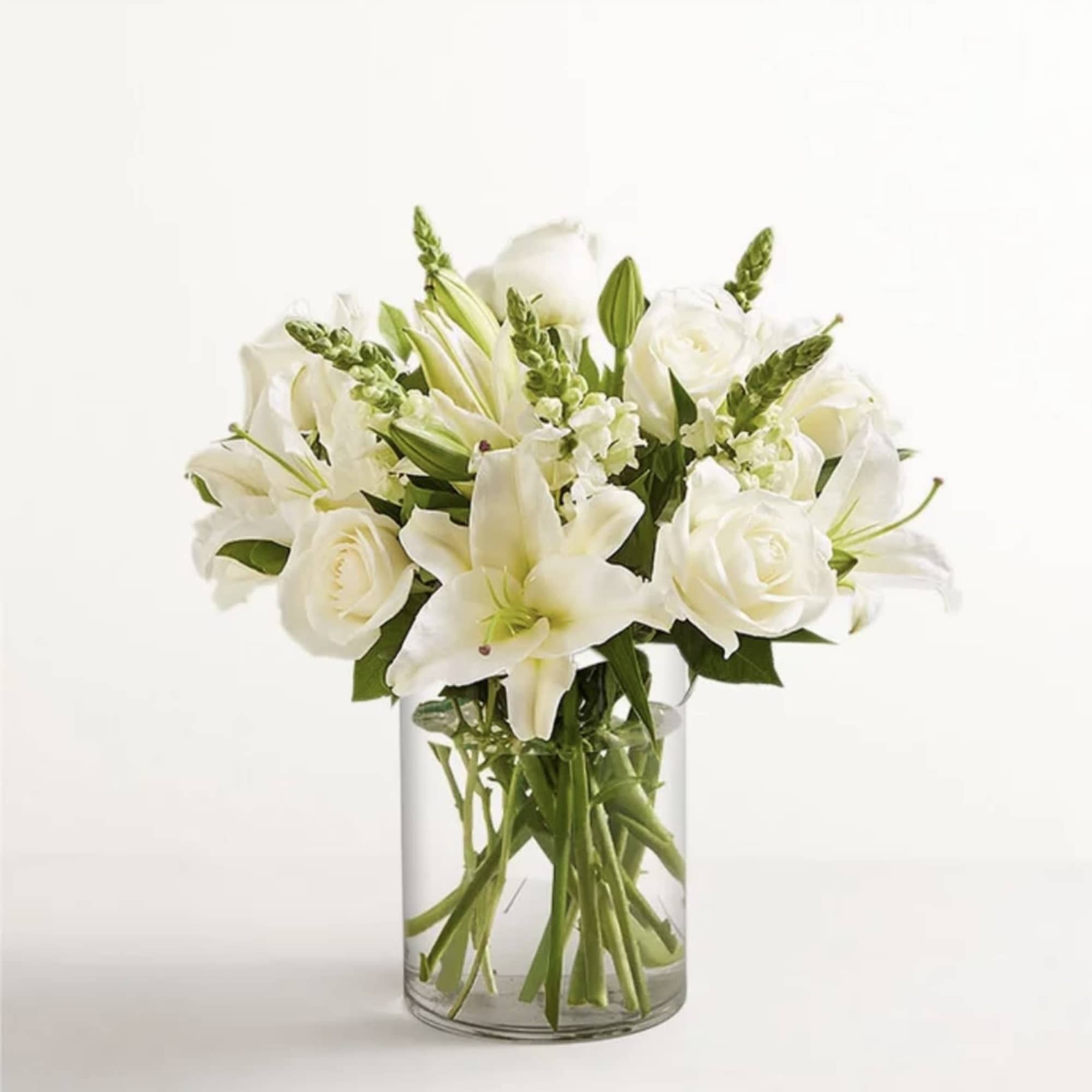 All-around arrangement with all white flowers, designed in a glass cylinder vase.
Standard