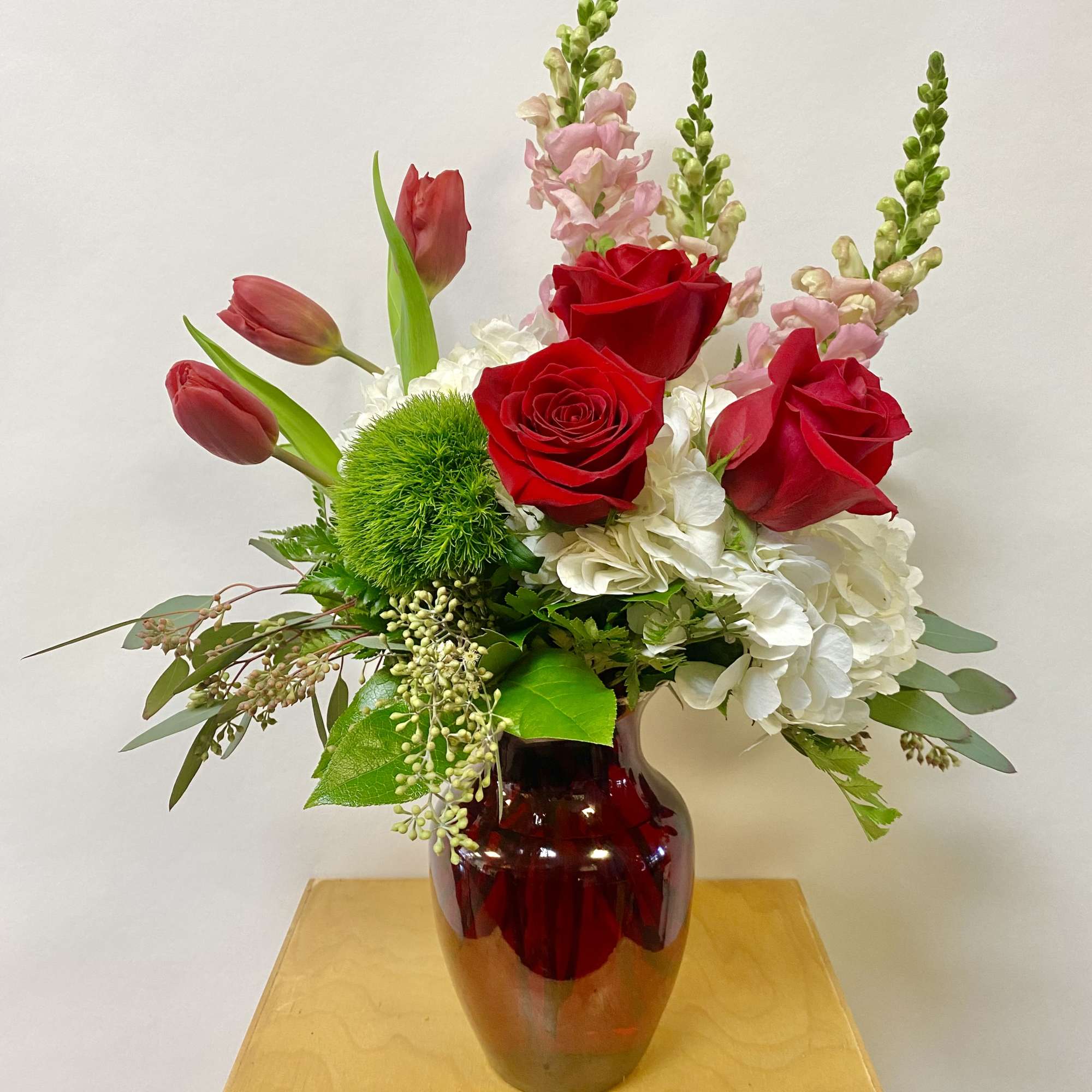 This Medium Arrangement Includes White Hydrangea's, Red Roses, Pink Snapdragons, Tulips, Green