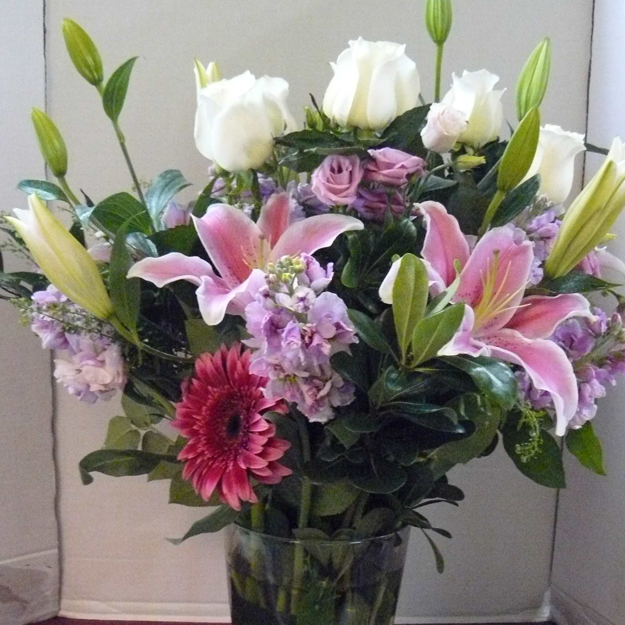 Lisianthus, Hybrid Lilies, Roses, Gerbera Daisies, Assorted Fancy Greens
This Arrangement in a
