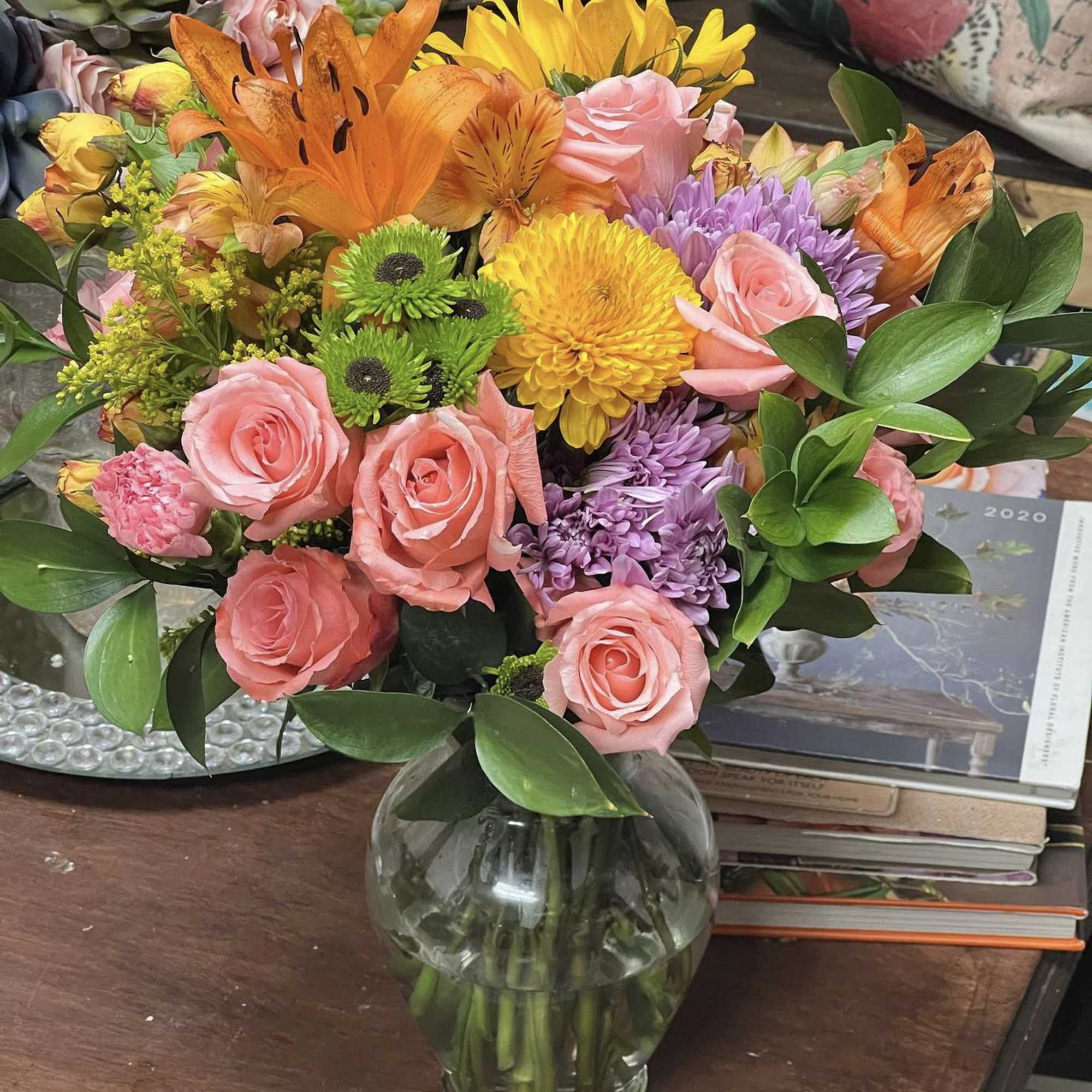 Designers Choice of Fall tones of fresh cut florals in Clear Vase