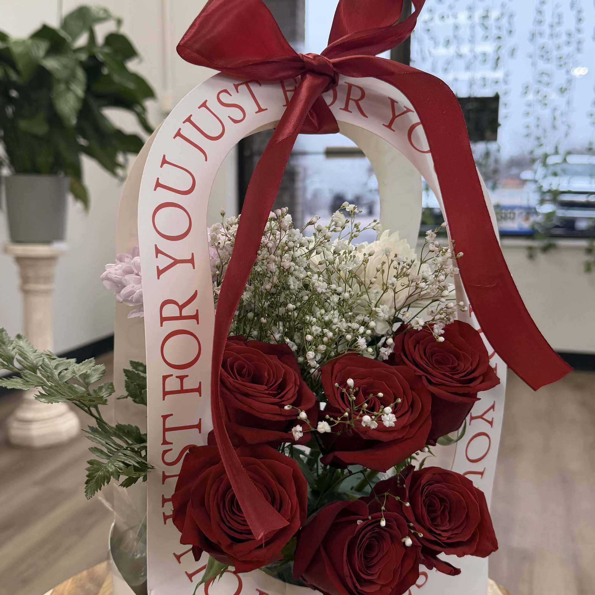 Classic red roses with baby&rsquo;s breath, artfully arranged in a gift bag
