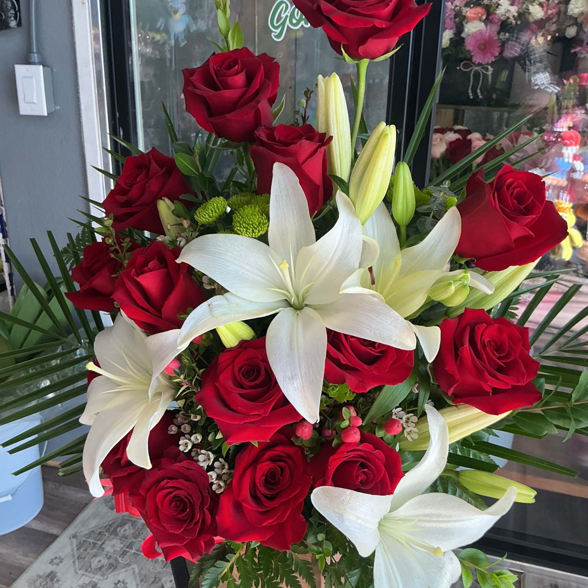 This beautiful arrangement is made of red roses and white lilies 